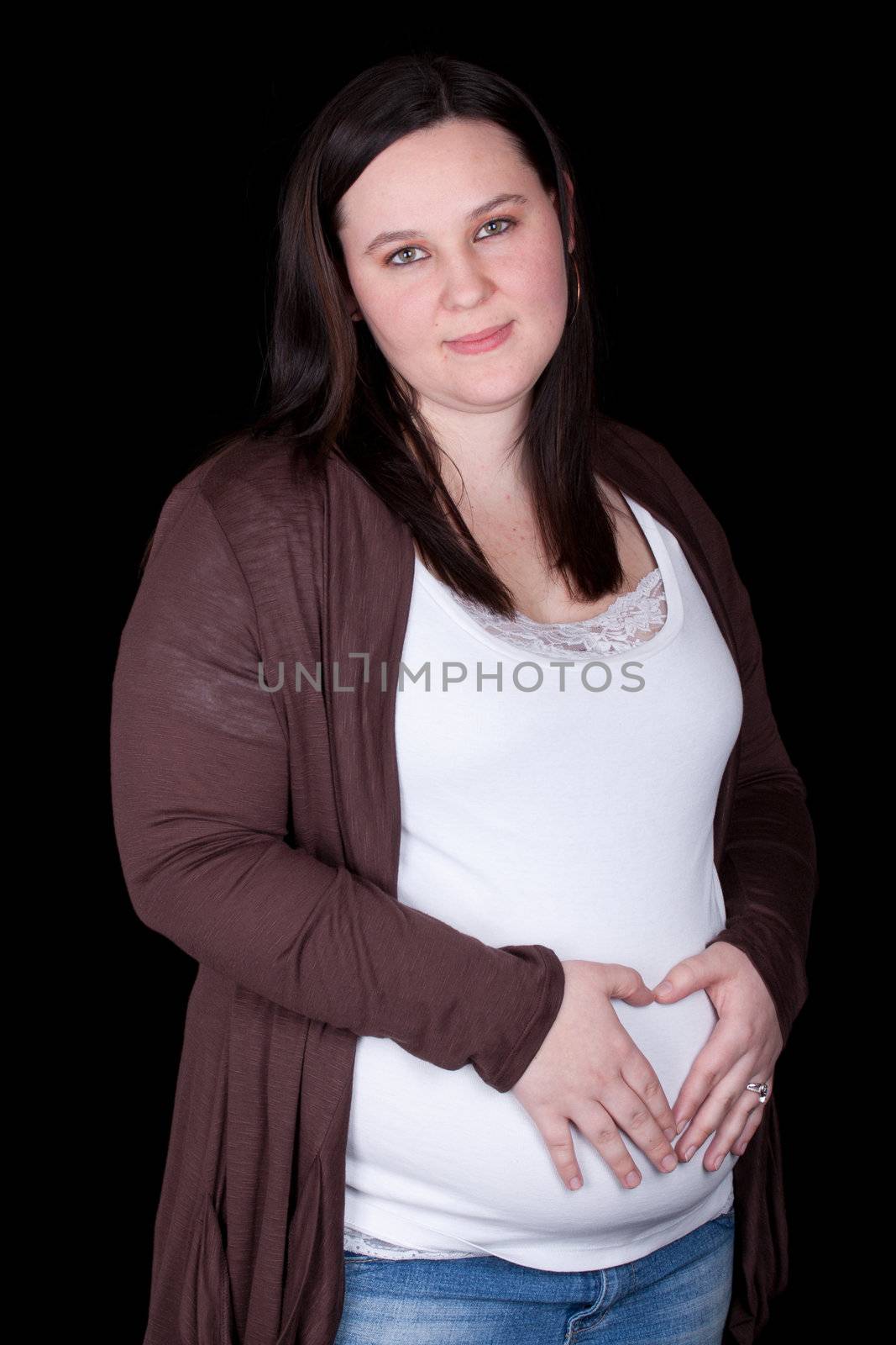 A beautiful mom holds her stomach and looks at the viewer.