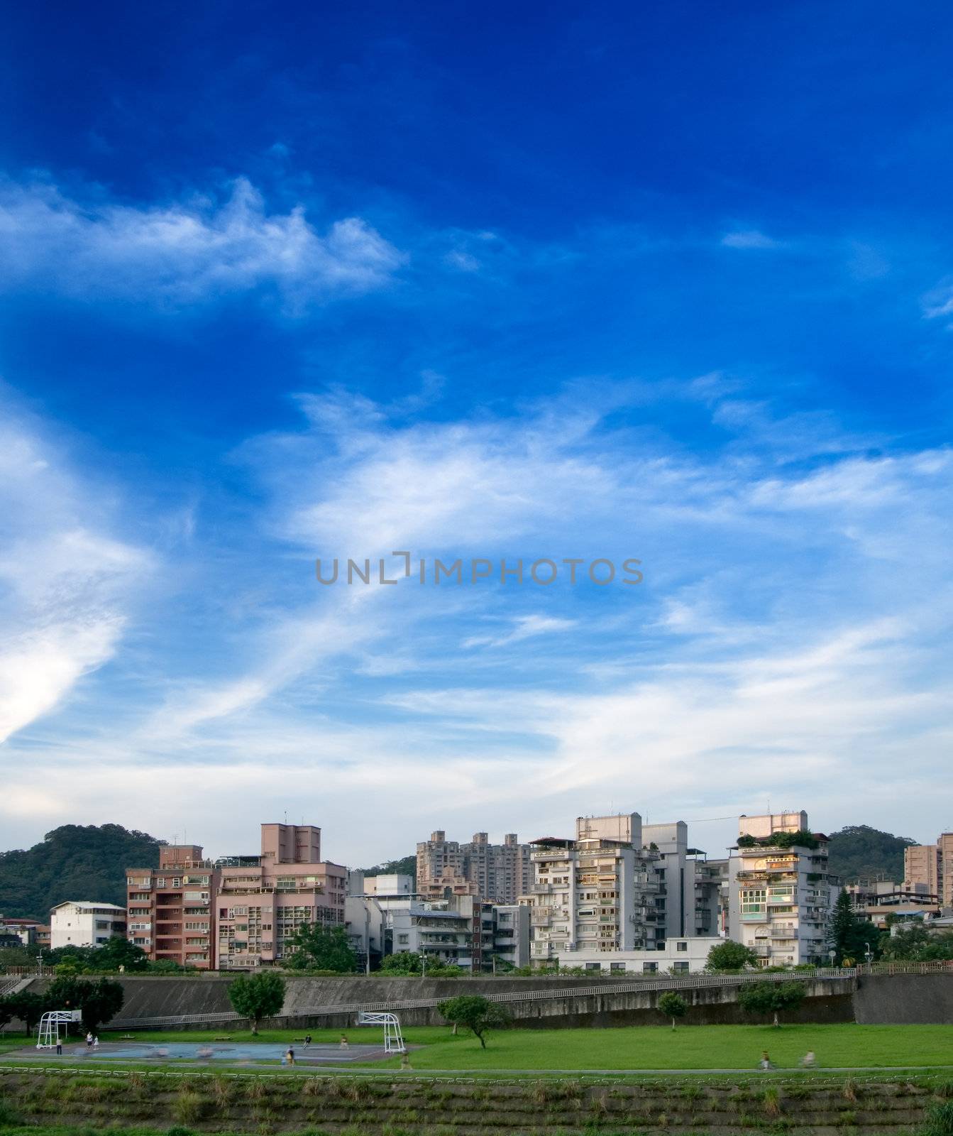 Here is a cityscape of apartment with blue sky.
