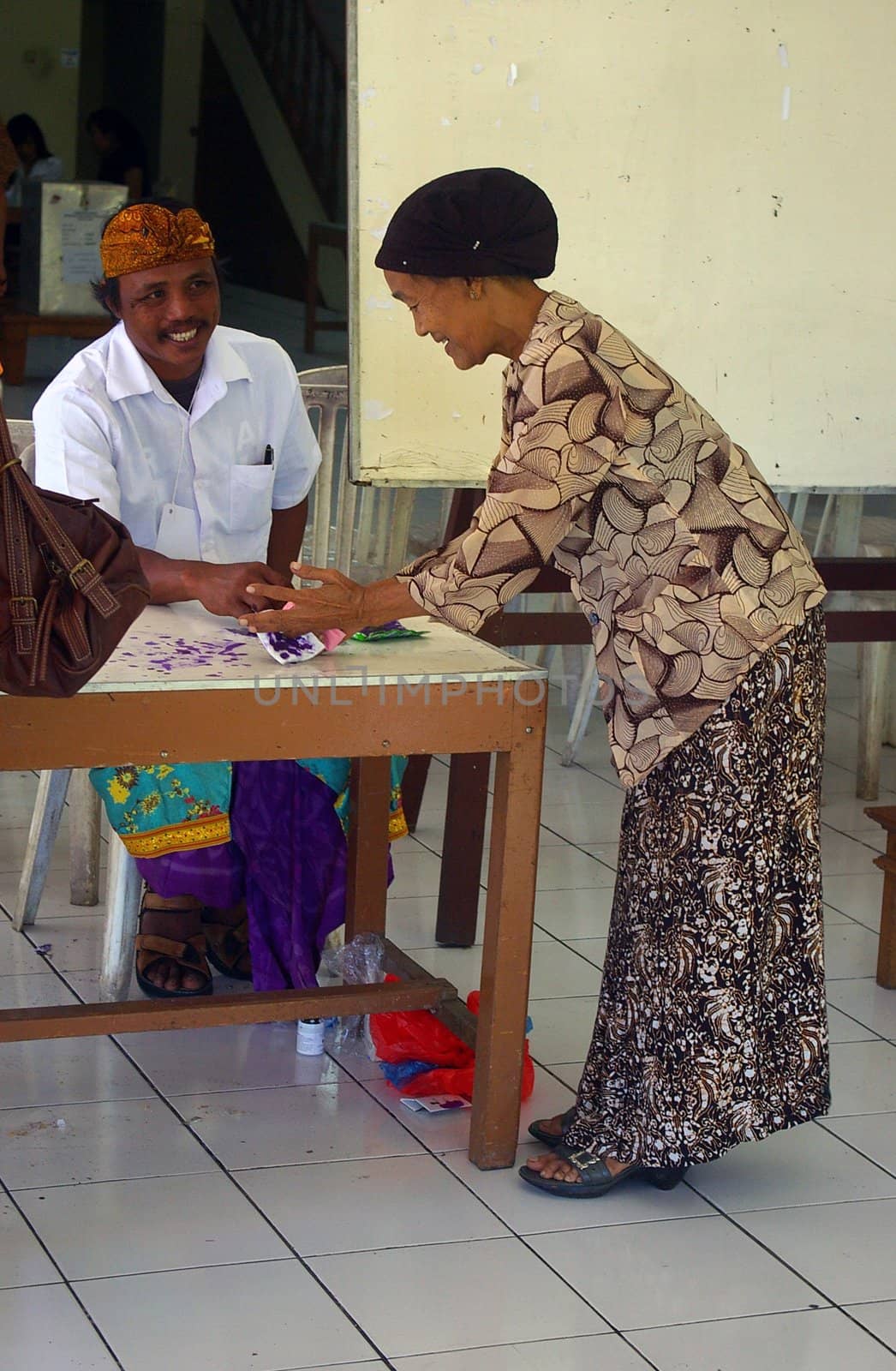 A woman applying ink to her finger as a mark to show she has already voted in Indonesia's Presidential election. Tuban, Bali, Indonesia. July 8, 2009.