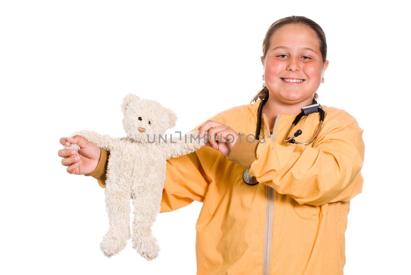 A young girl holding up a stuffed bear while wearing a stethoscope, isolated against a white background