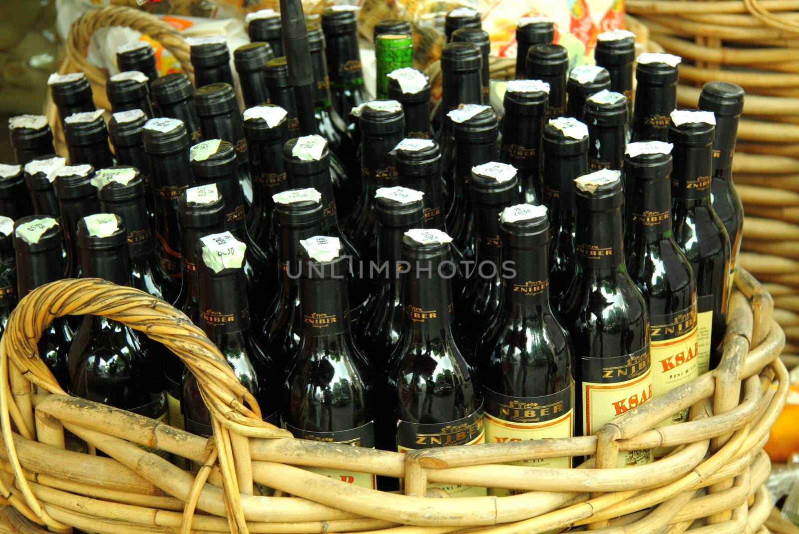 Basket full of bottles of red wine for sale in a street market in France 