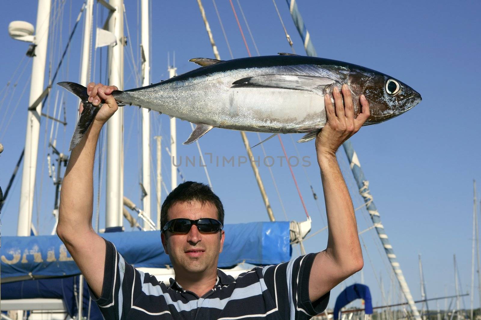 Big game fisherman with saltwater tuna catch in his hands