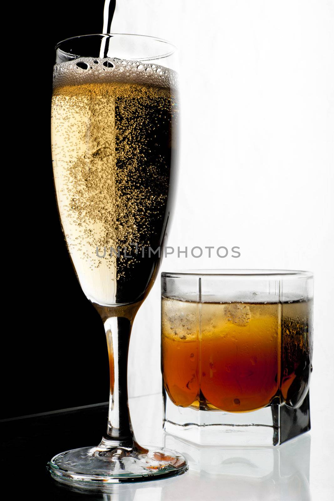 Glass of champagne and whisky with ice. A black and white background.