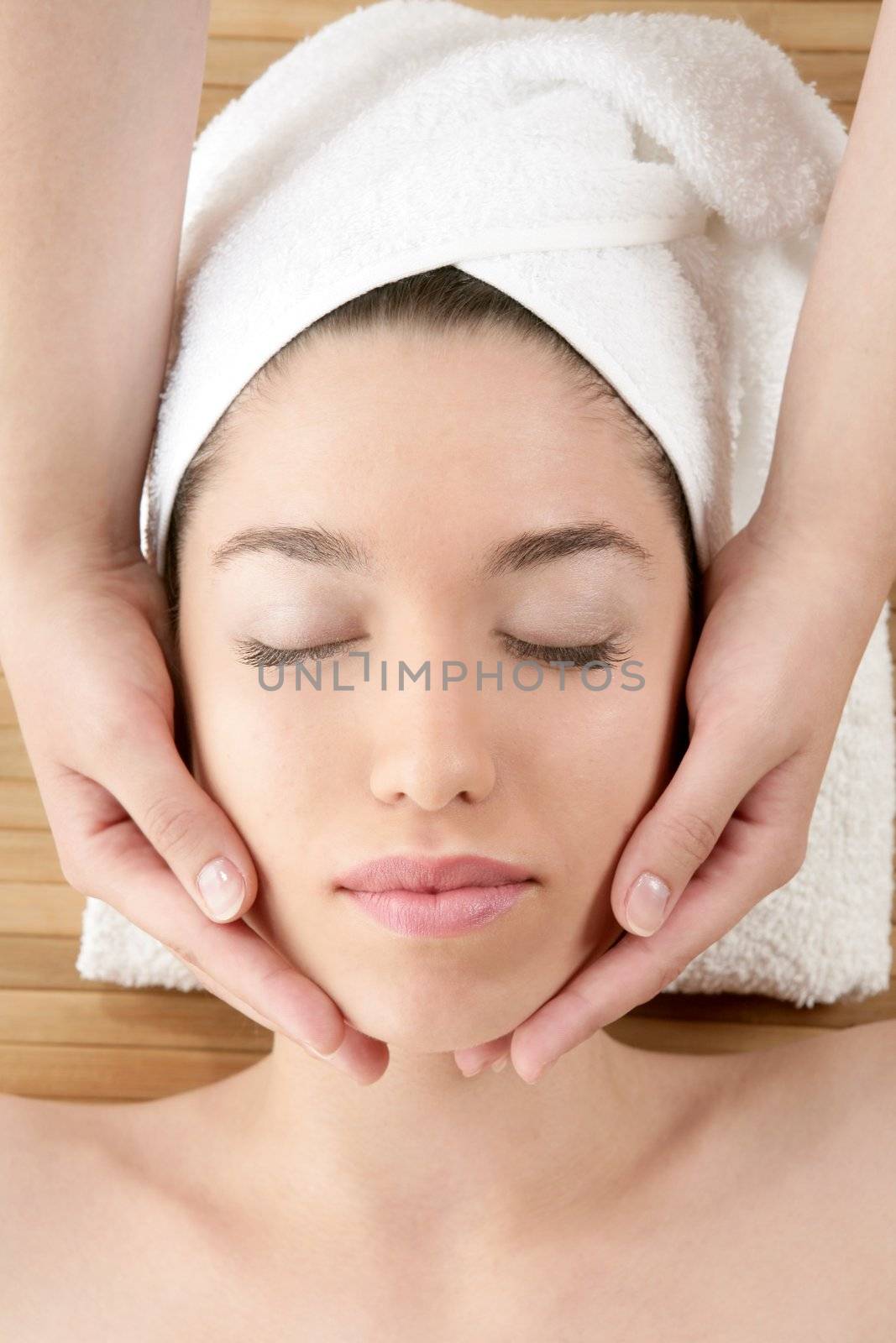 Beautiful woman face massage with white towel by lunamarina