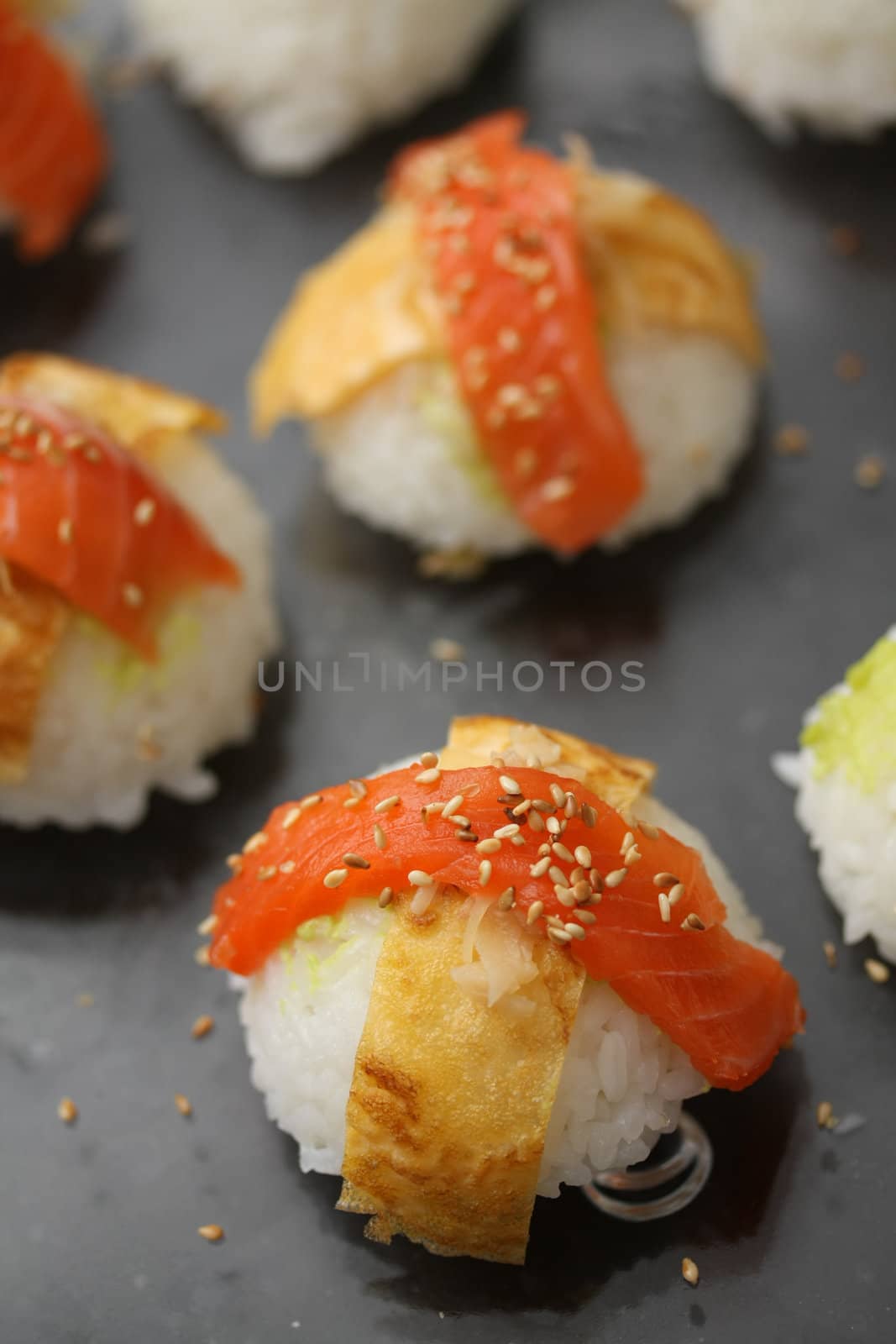 Pieces of nigirisushi: rice with a salmon or scrimp topping, decorated with sesame seeds