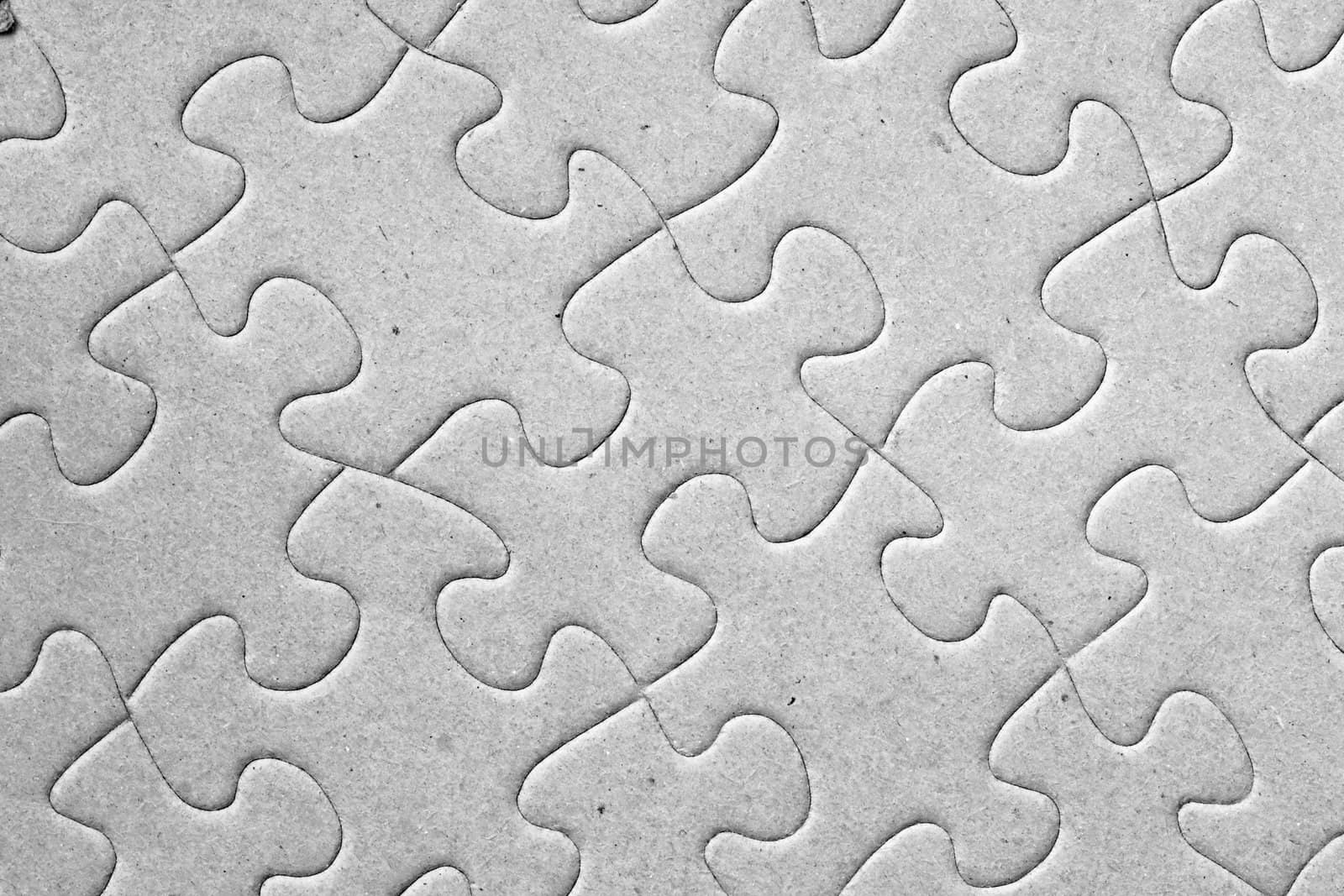 Blank grey complete cardboard jigsaw puzzle shot at an angle, great details on the pieces