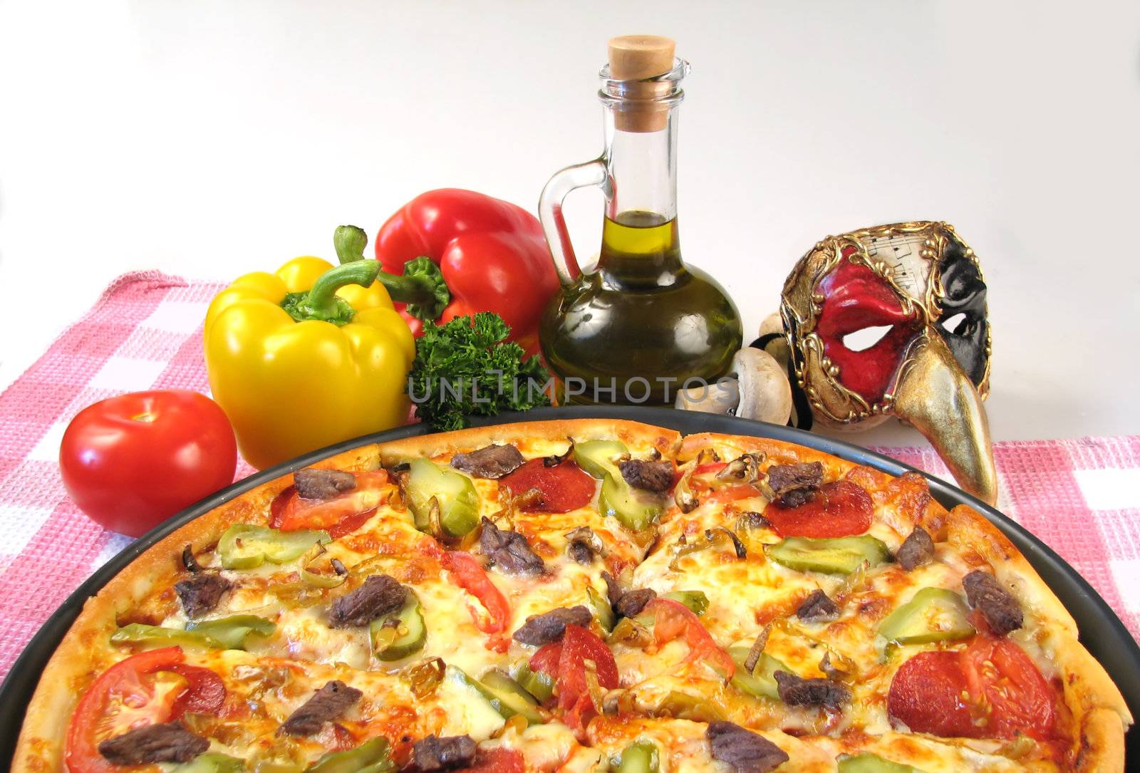 Composition from a pizza, vegetables and the Italian mask. �lose up