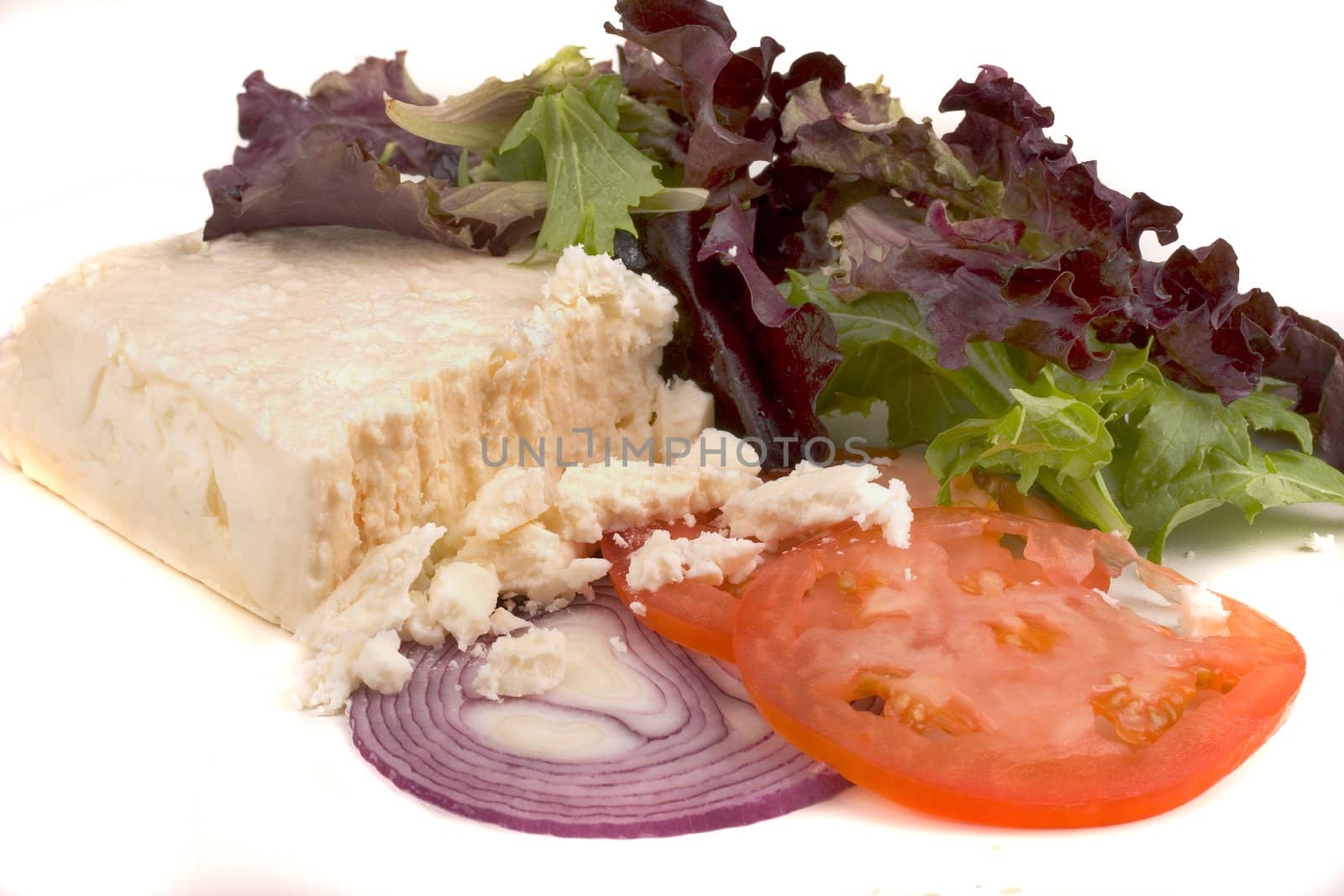 Feta cheese with vegetables on a white background