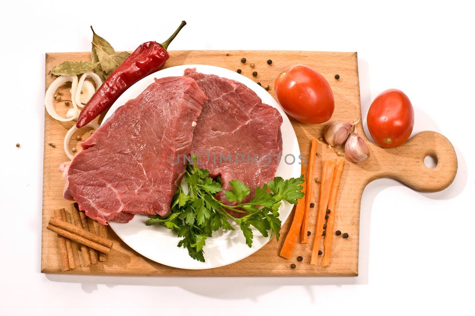 raw meat and vegetables on the wood board