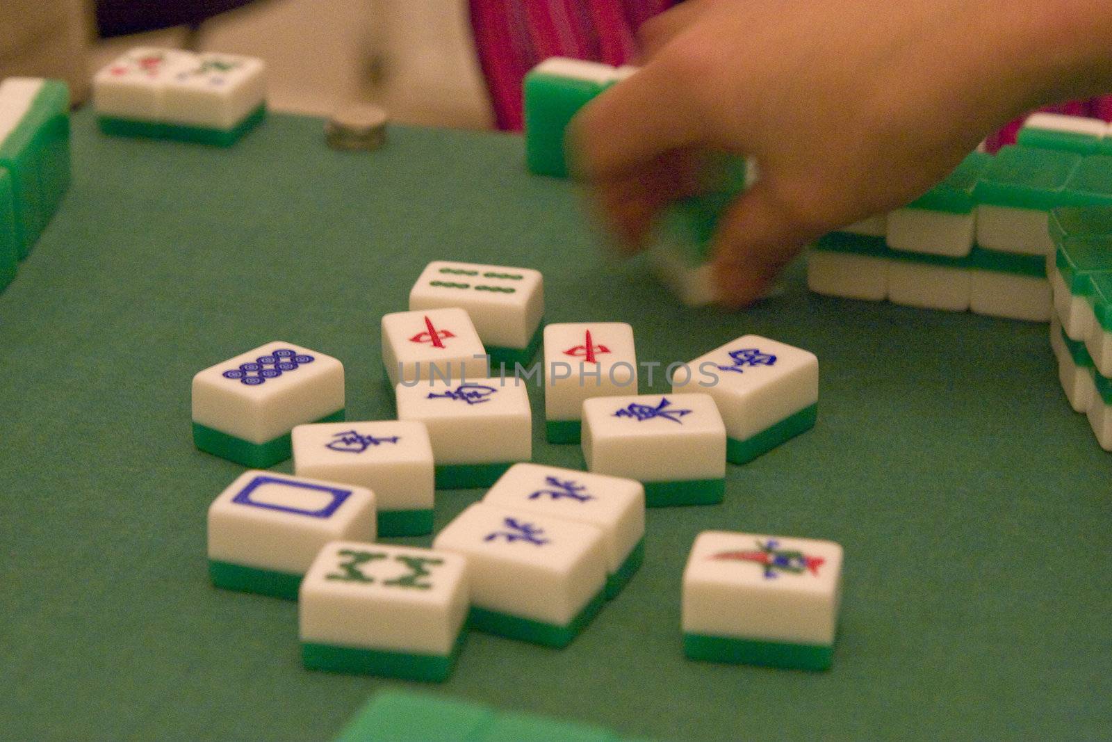 a hand picke a tile in a mahjong game