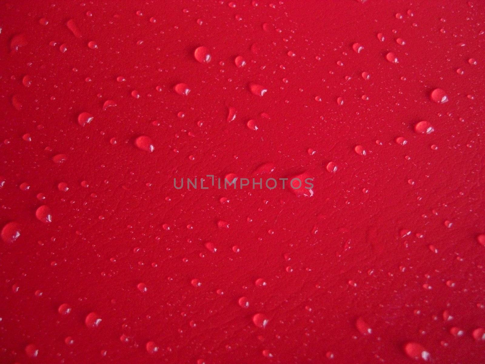 waterdrops distributed on red leathery background