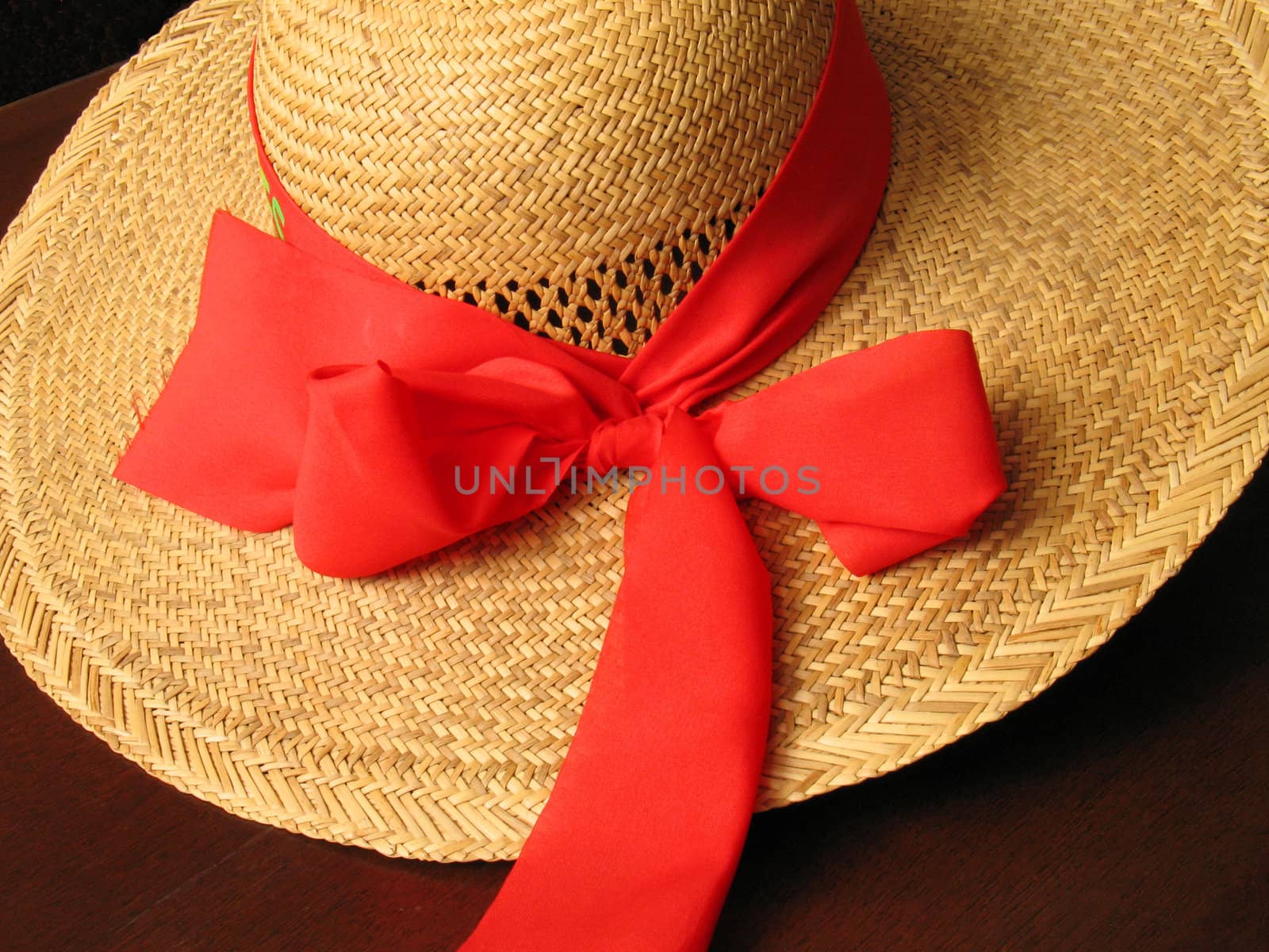 straw hat with red bow on dark background