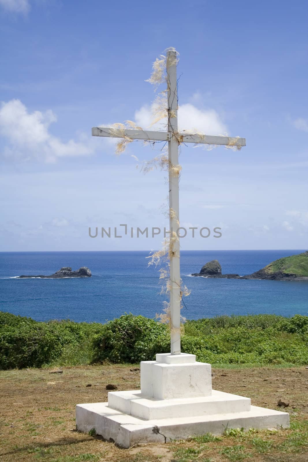 A simple white, wooden cross with the great blue ocean in the background!