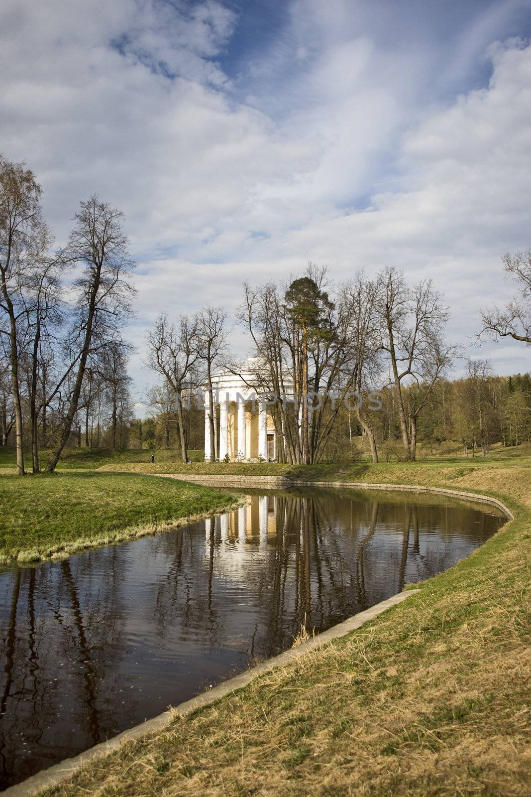 Classical rotunda near river in spring park