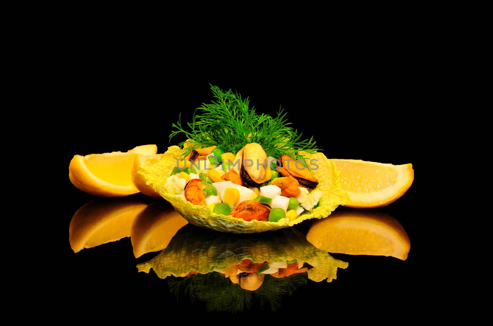 Salad of mussels with corn and peas in the leaves of savoy cabbage on a black background