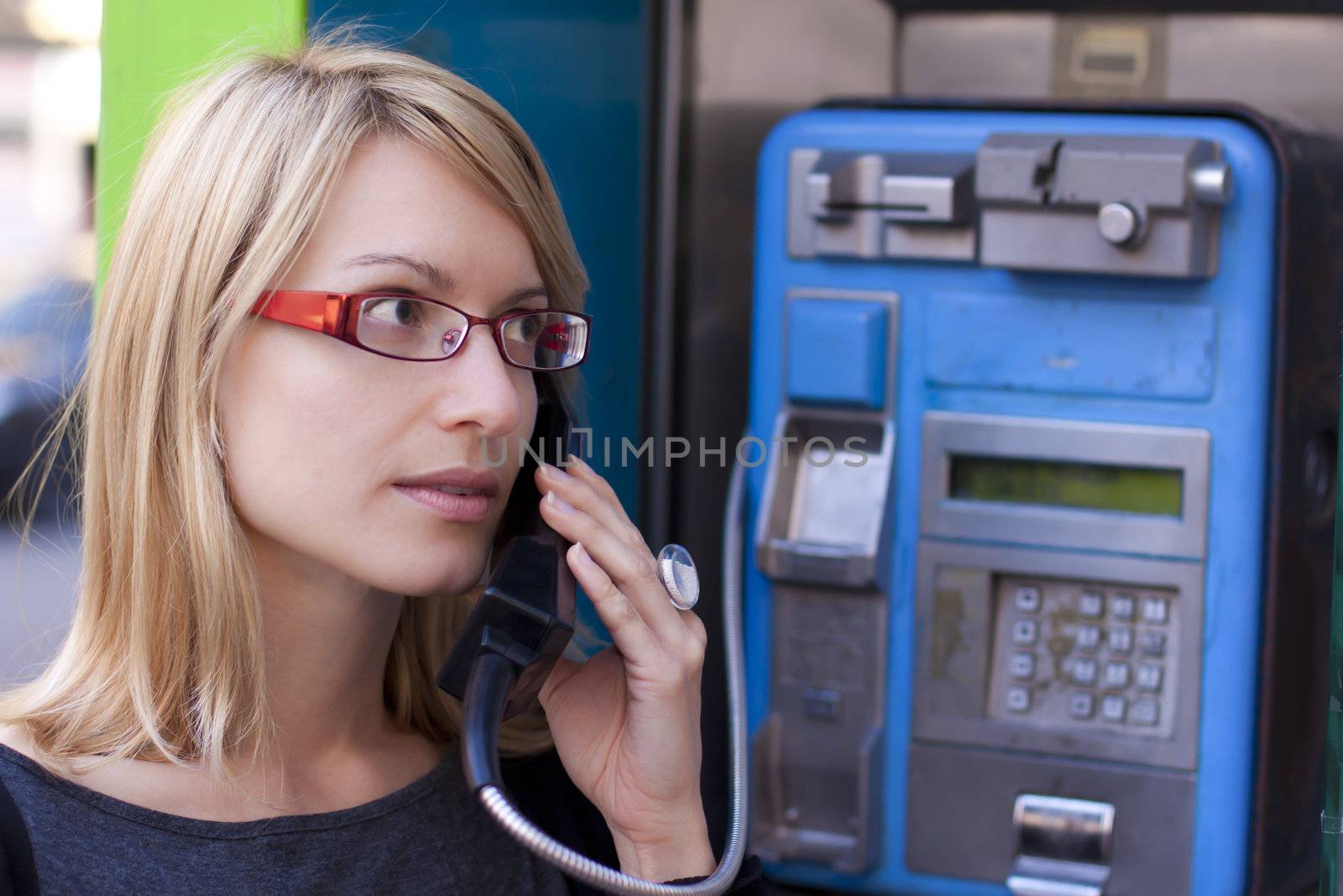 Woman talking on the phone in a retro phone boot