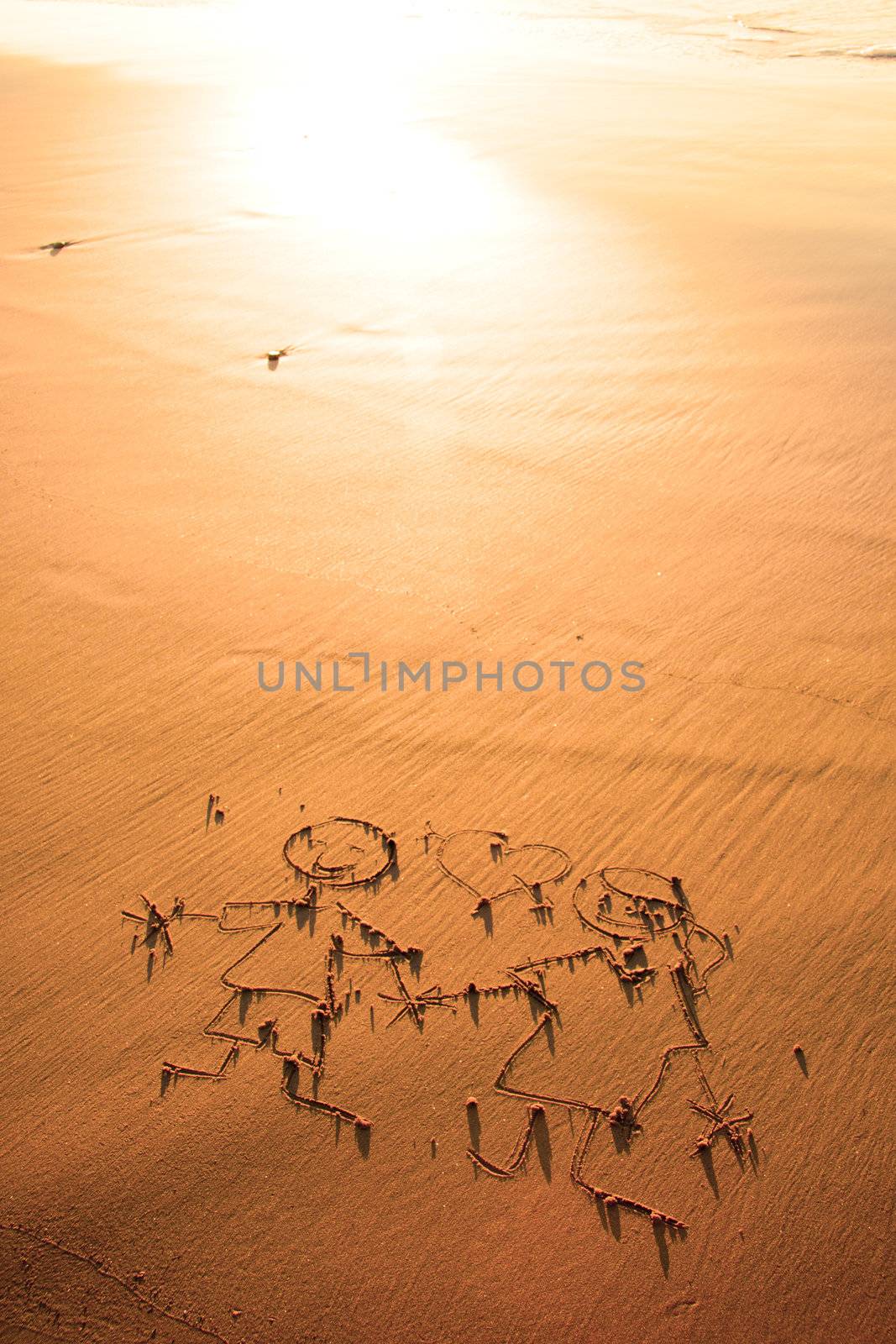 Two children holding hands drawn in the sand on the atlantic coast