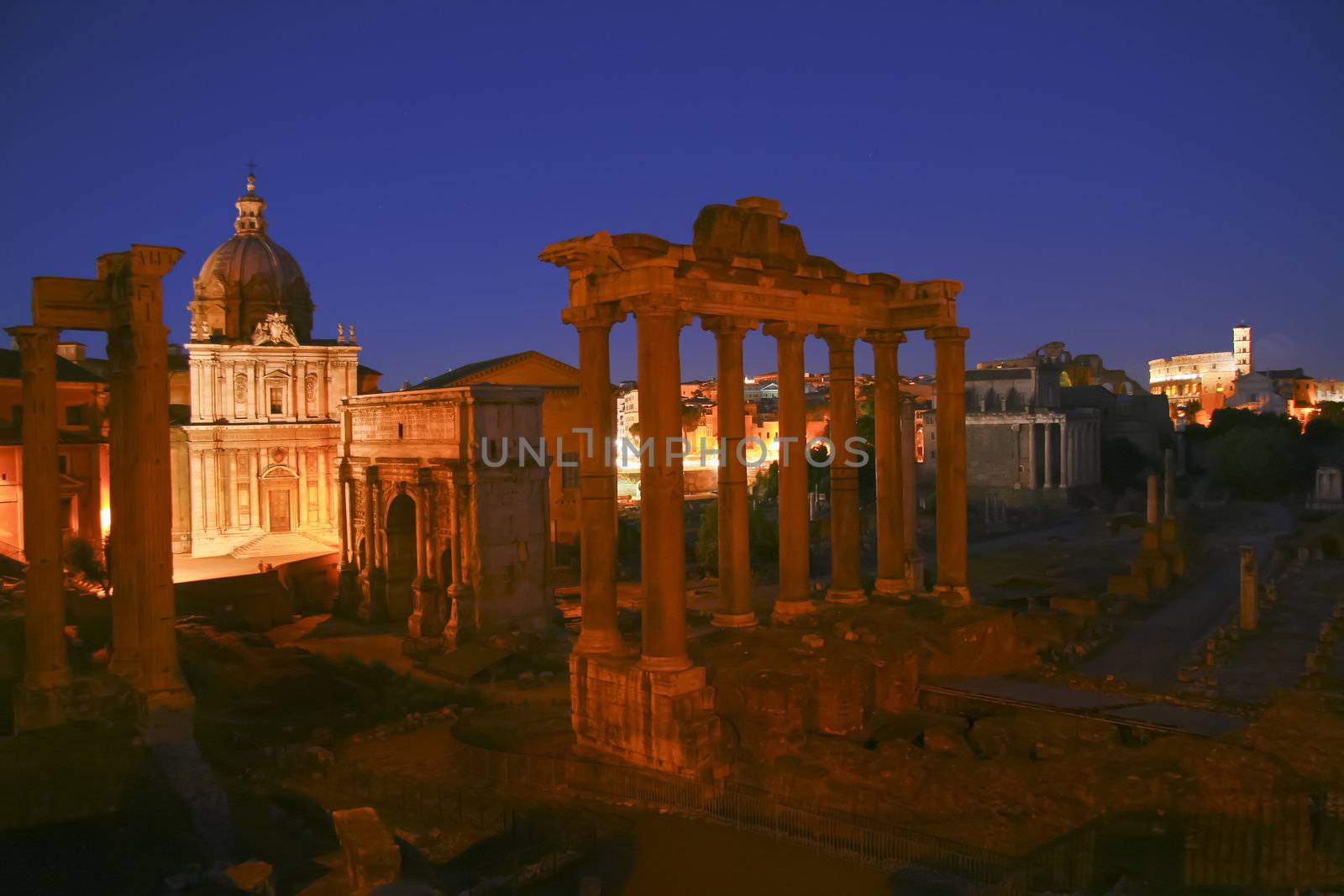 Ruins of the ancient roman empyre shot at dask with the coloseum in the background