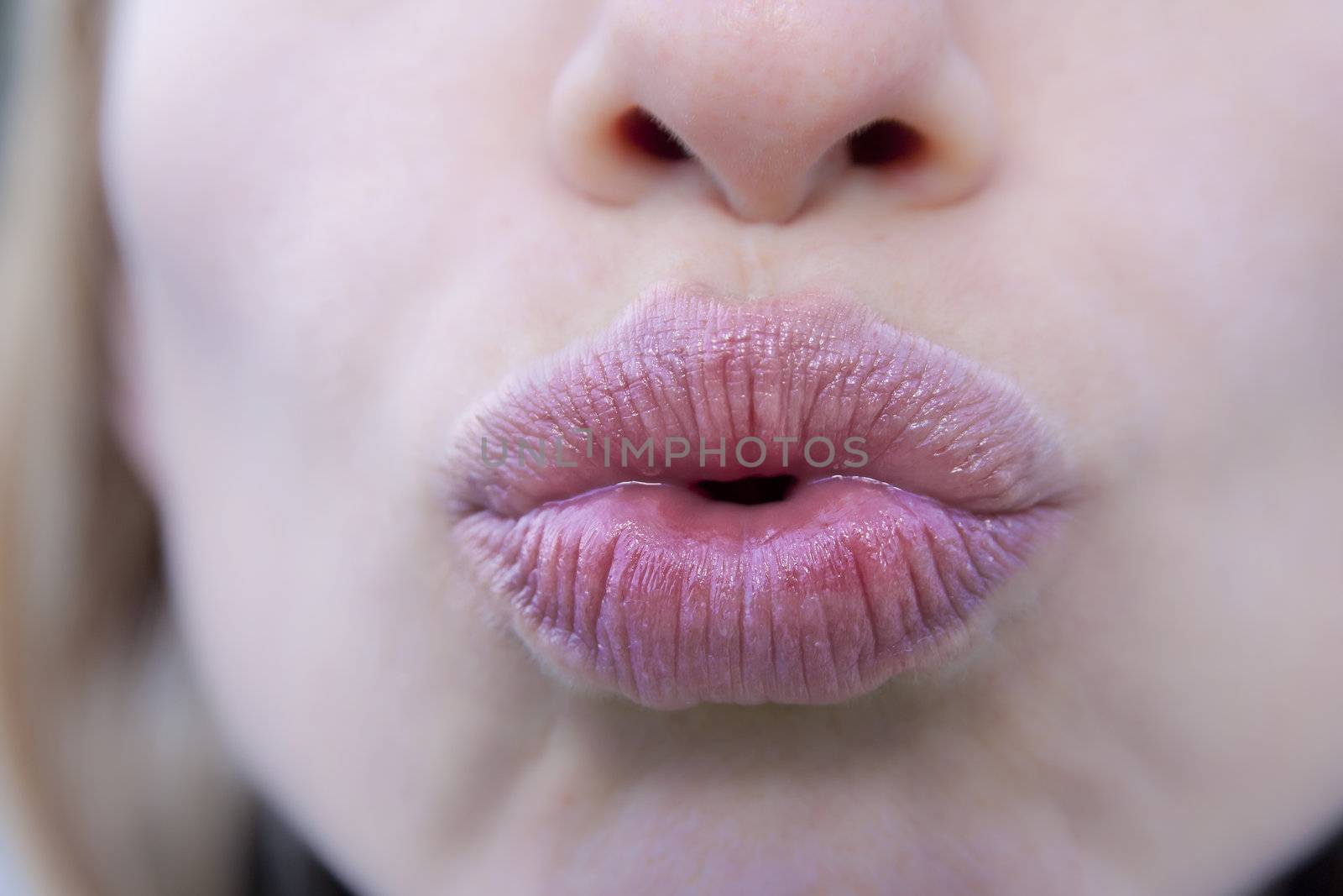 Young atractive woman doing the kiss gesture.