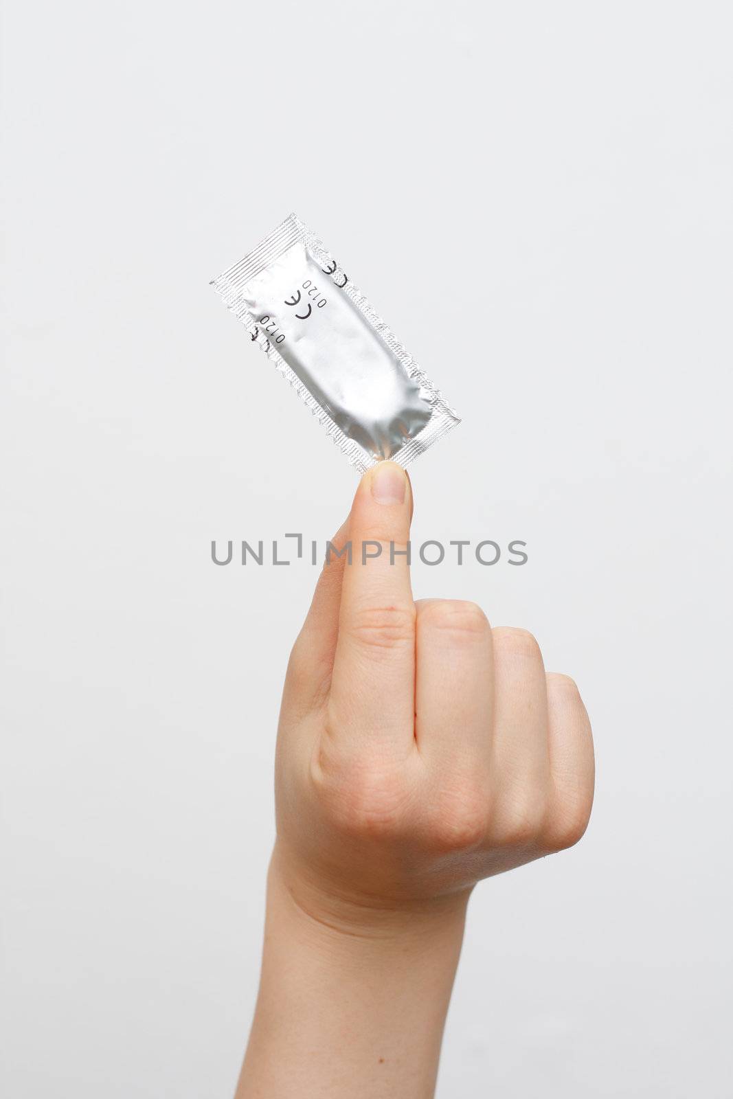 A female hand holding a condom