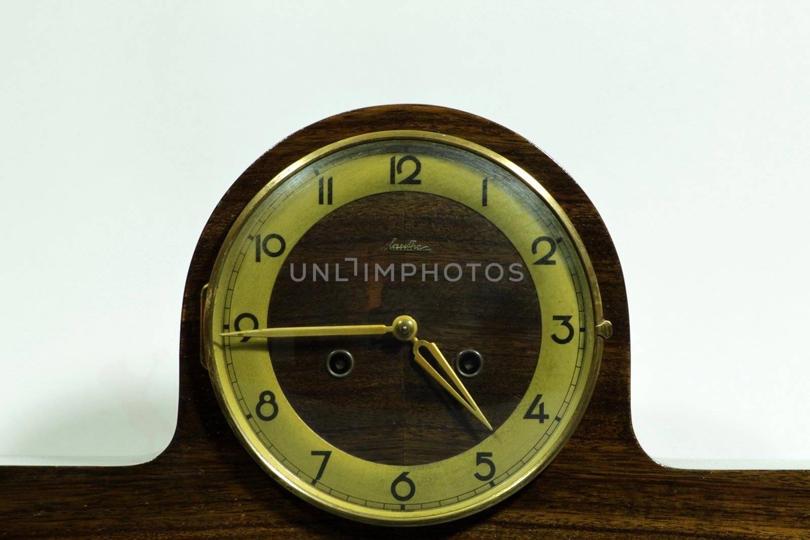 Old mantel clock with time set at quarter to five