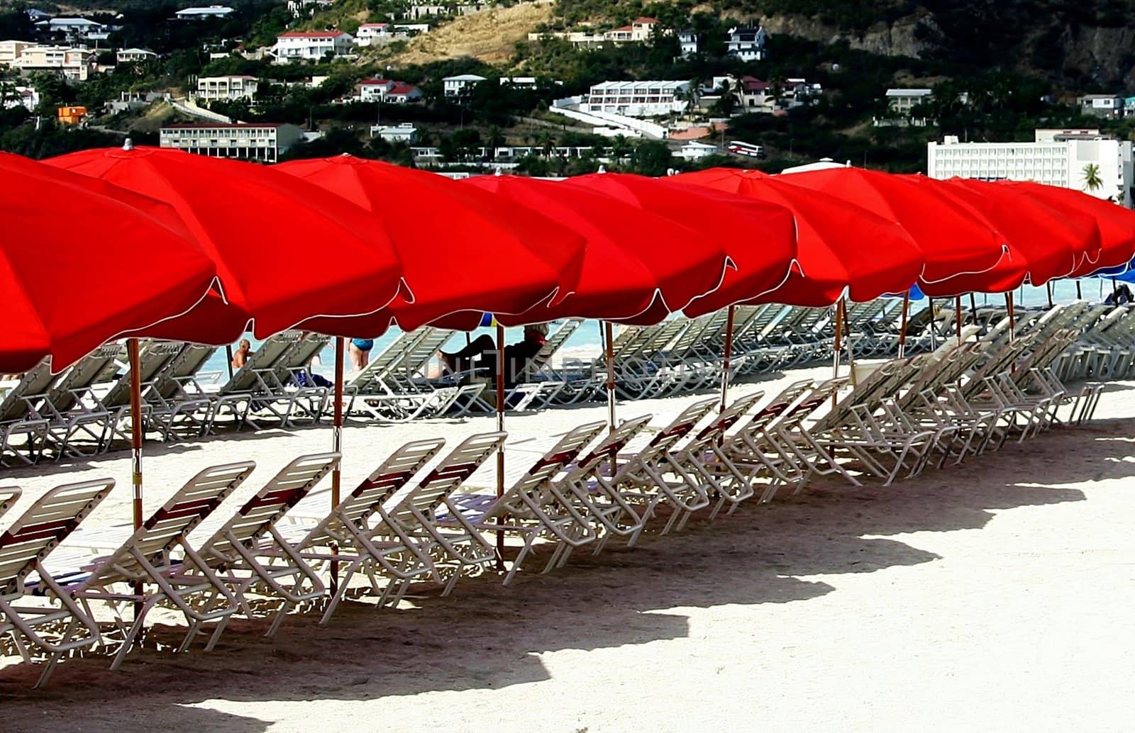 Beach chairs with red parasols