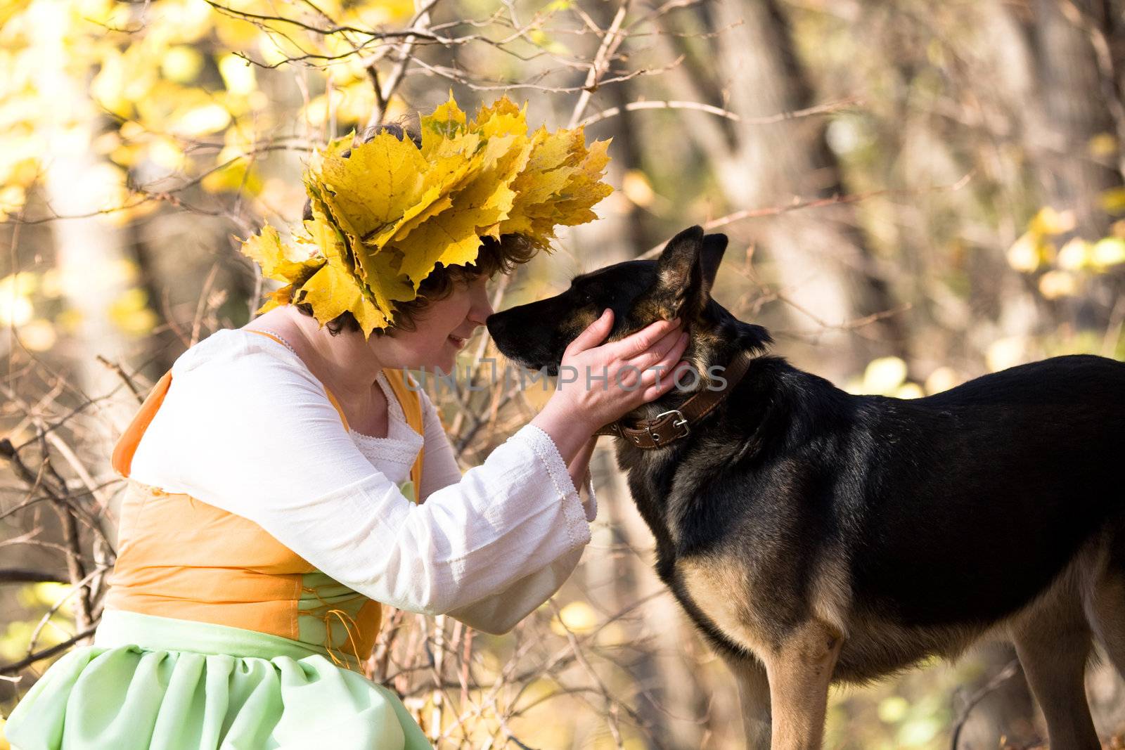 Woman and dog in autumn forest
