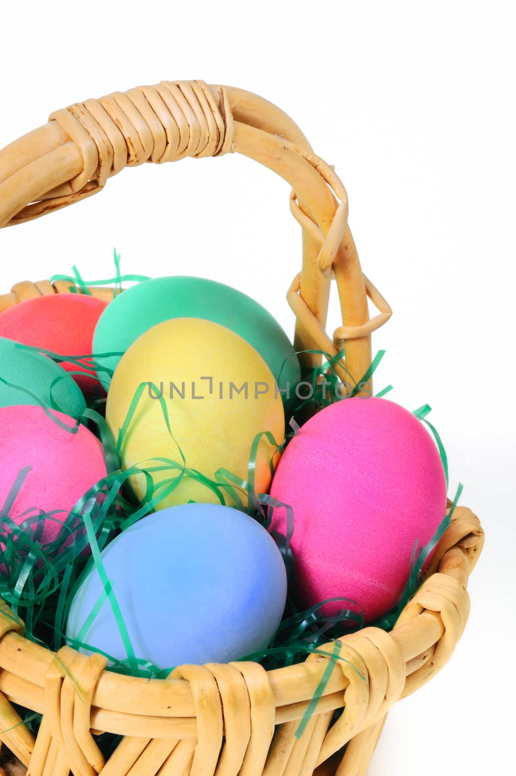 Easter colored eggs in the basket on the white background 