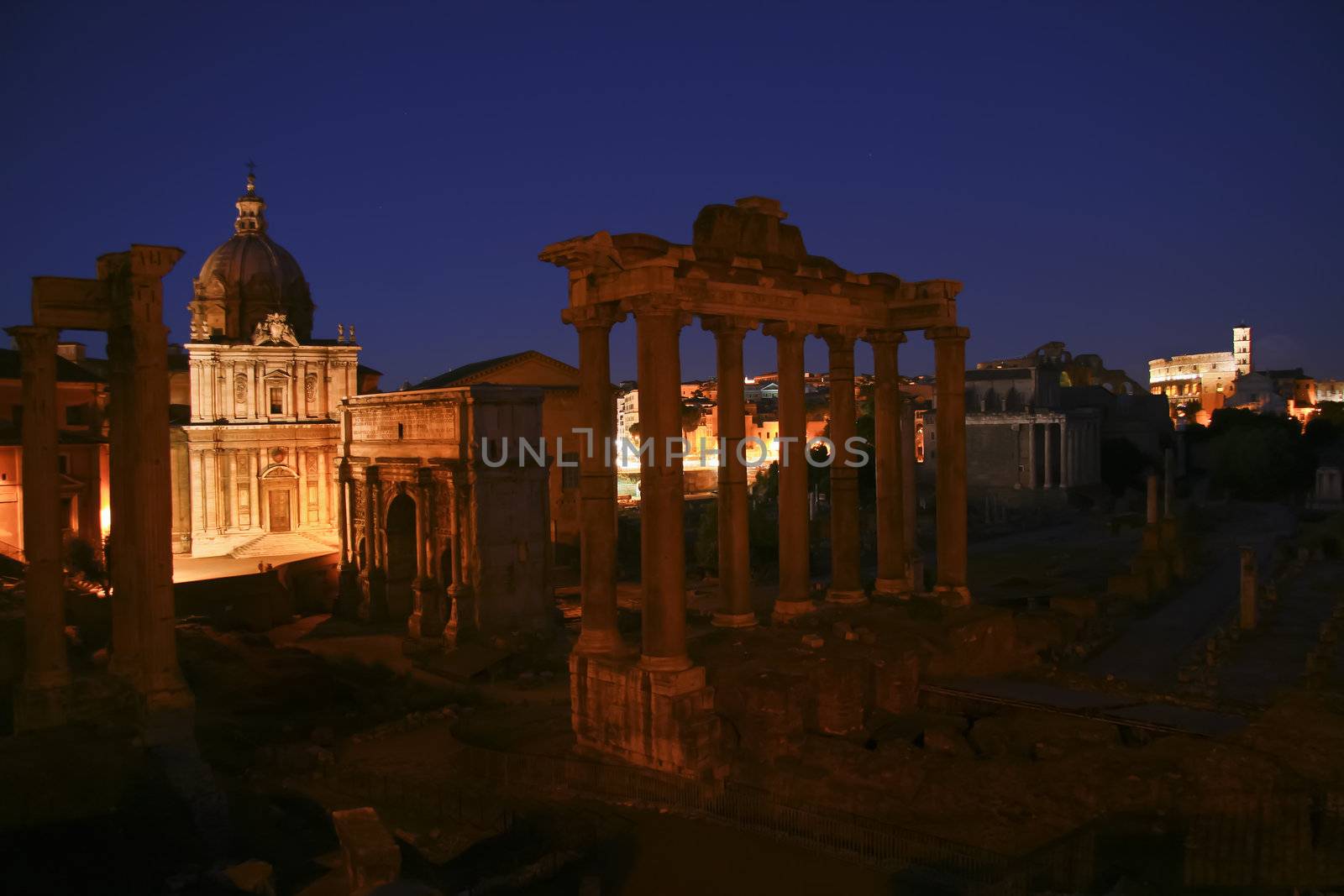 Ruins of the ancient roman empyre shot at dask with the coloseum in the background