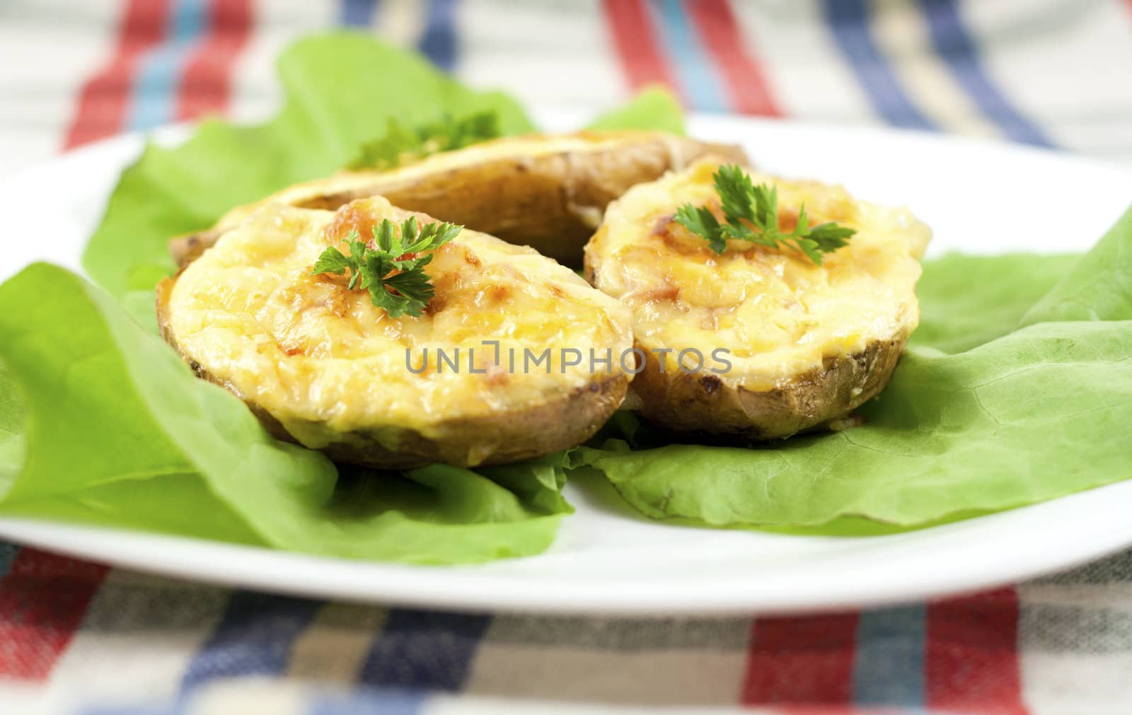 Salad with baked potatoes filled with cheese, ham and eggs, decorated with lettuce and parsley.