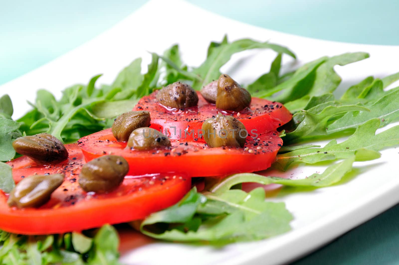 Salad with fresh tomatoes, capers and arugula by Apolonia