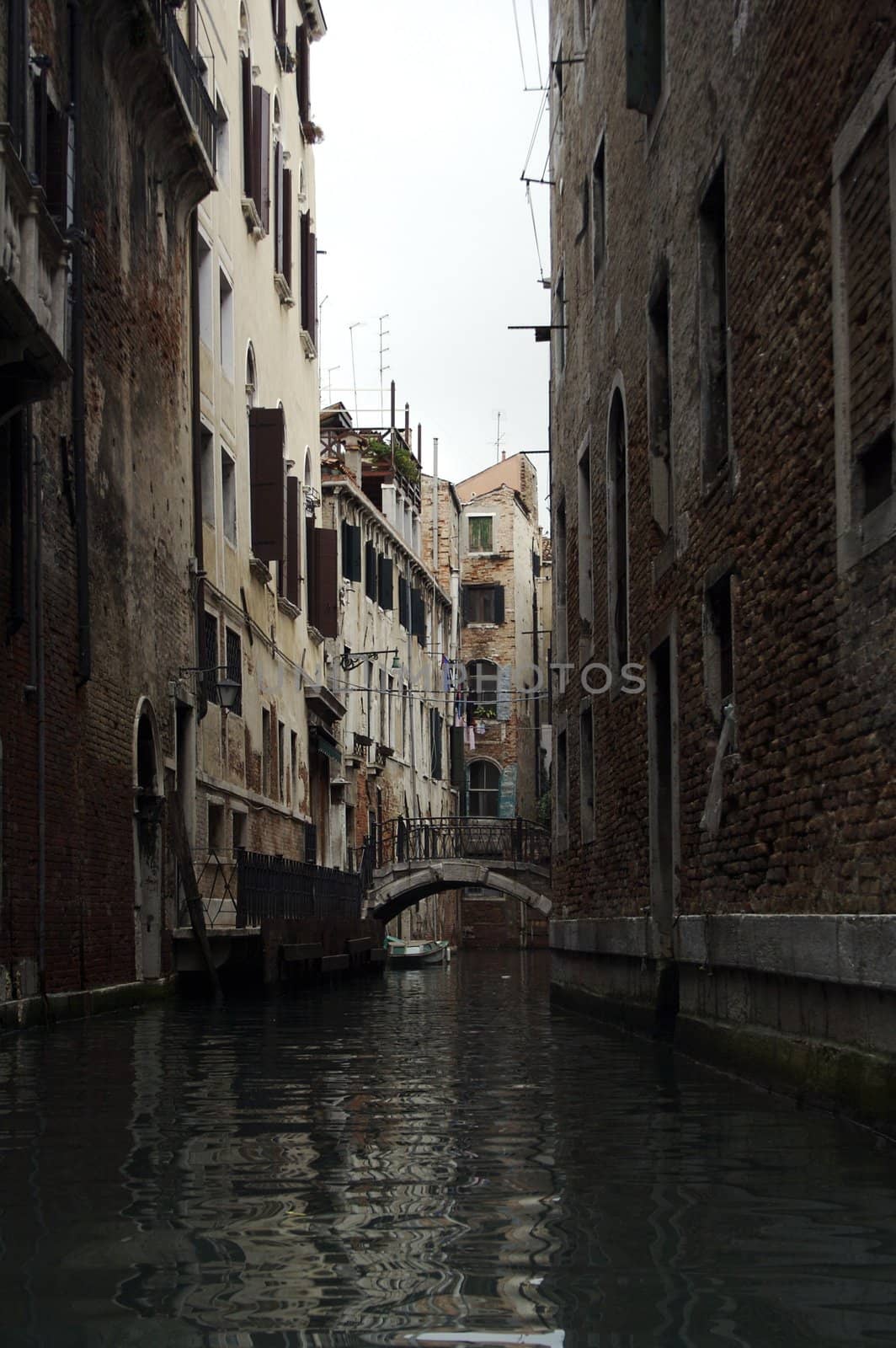 Narrow canal between old medieval houses in Venice