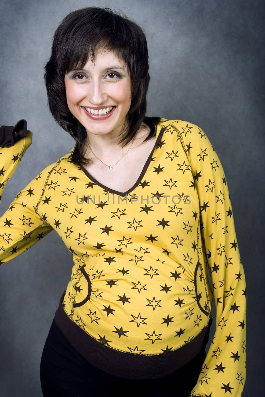 Energetic laughing expecting mother in a yellow pijamas with stars