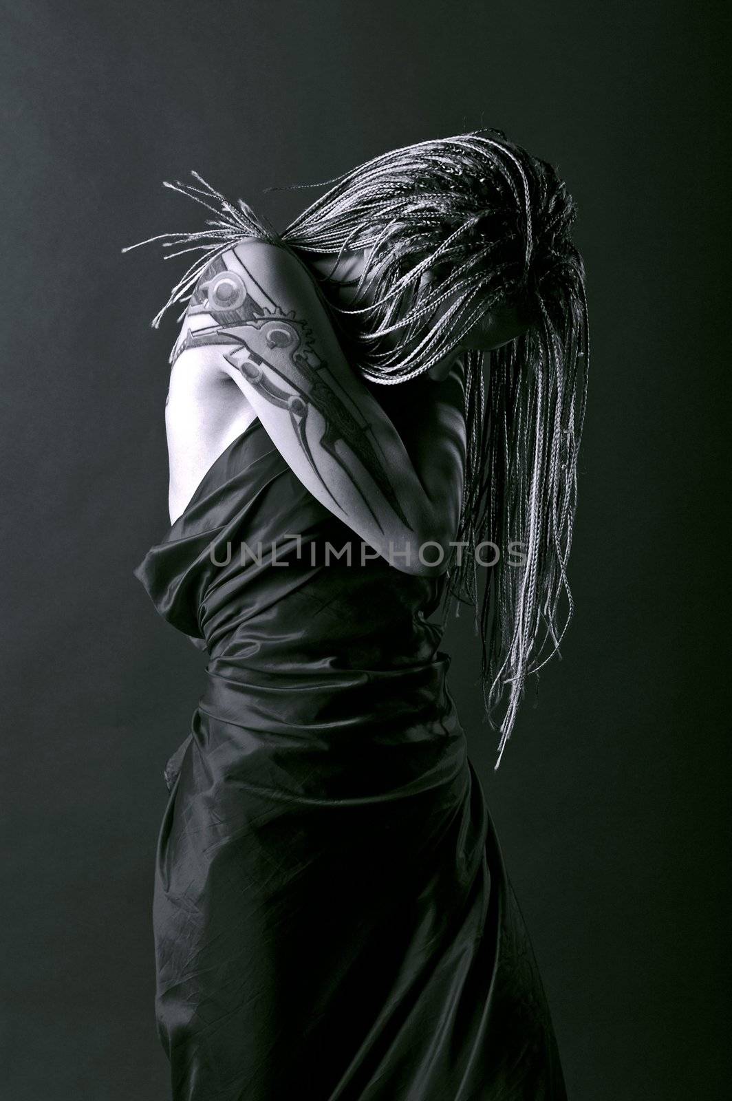 Mythic young girl with tattoo and braids looking down