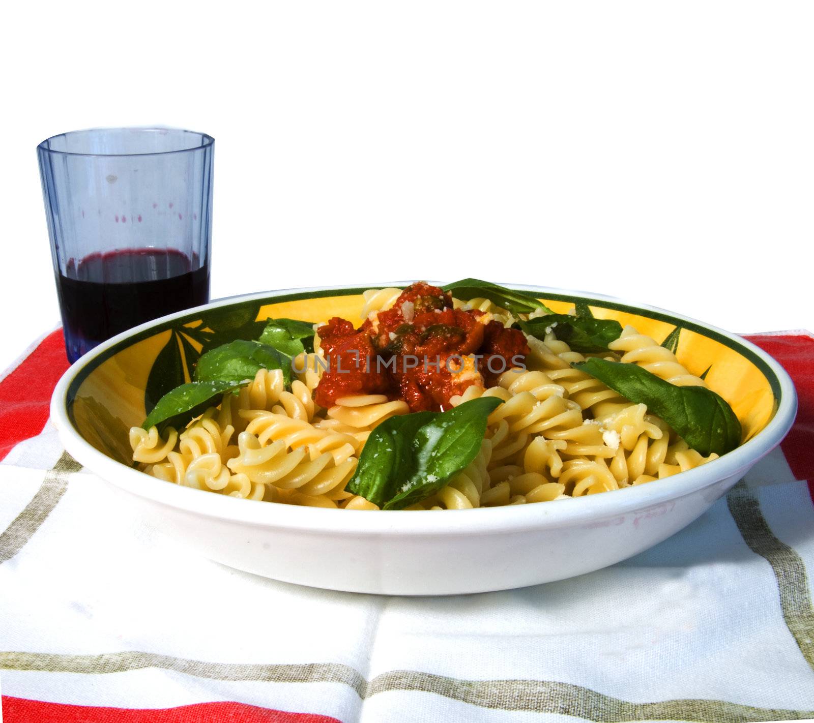 A plate full of italian pasta (fusilli al sugo), over a white background, with a glass of wine on the background