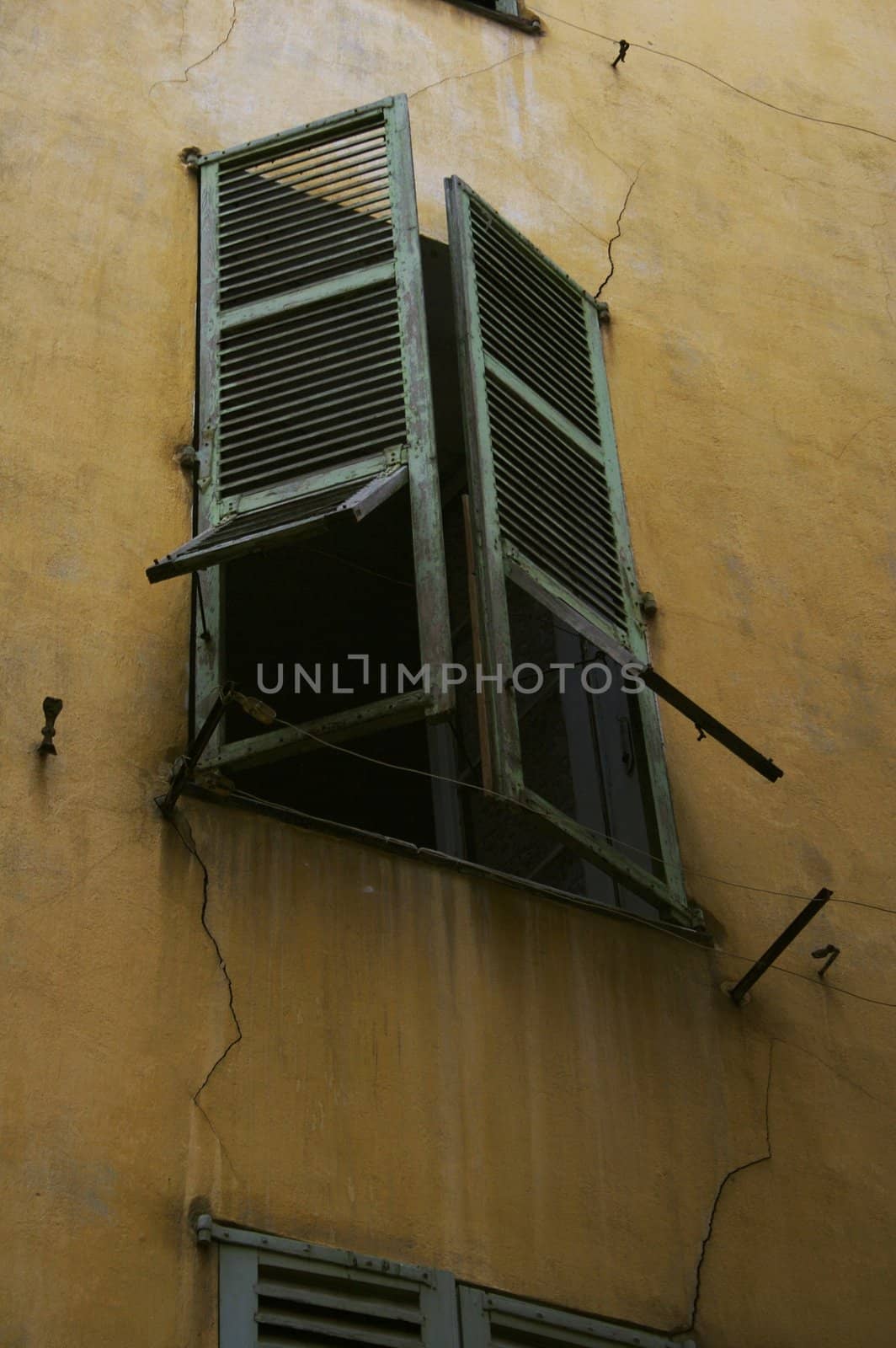 Window with green shutters in the old house