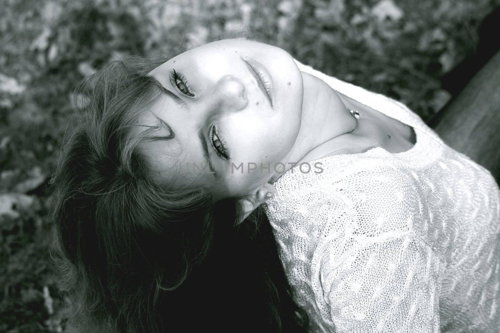 Charming young girl sitting in the park