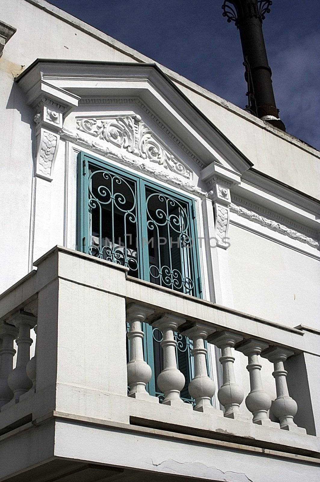 Romantic classical balcony of the white house with blue shutters