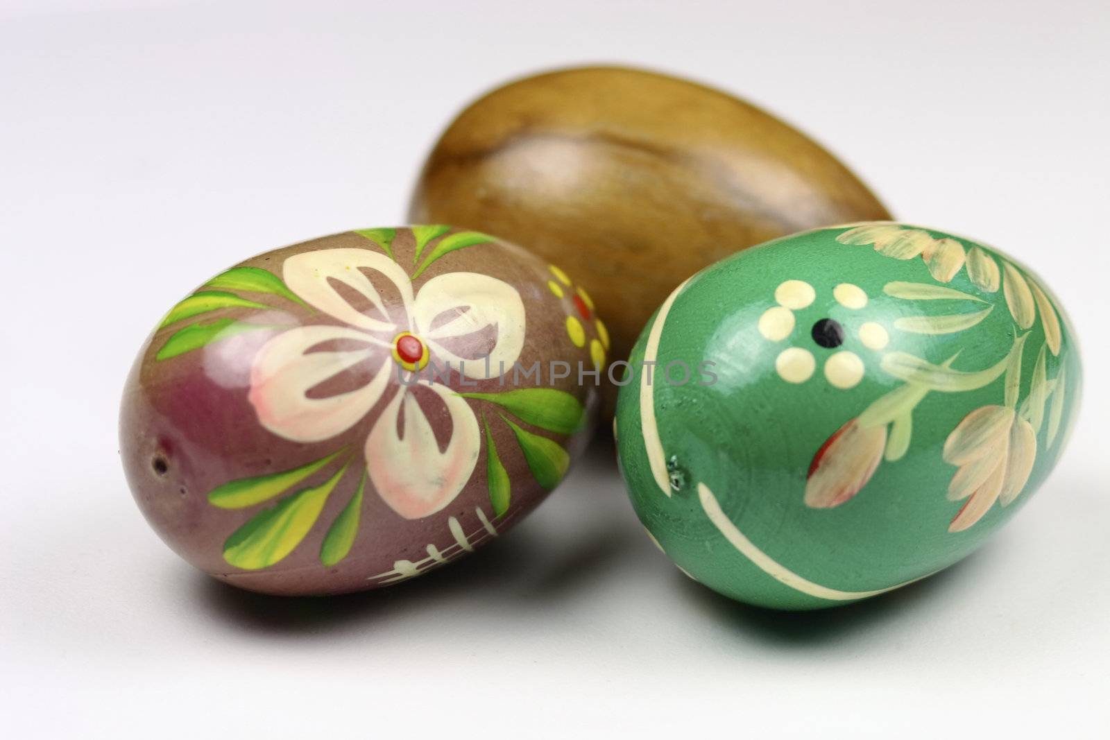 three wooden eggs decorated by leafy