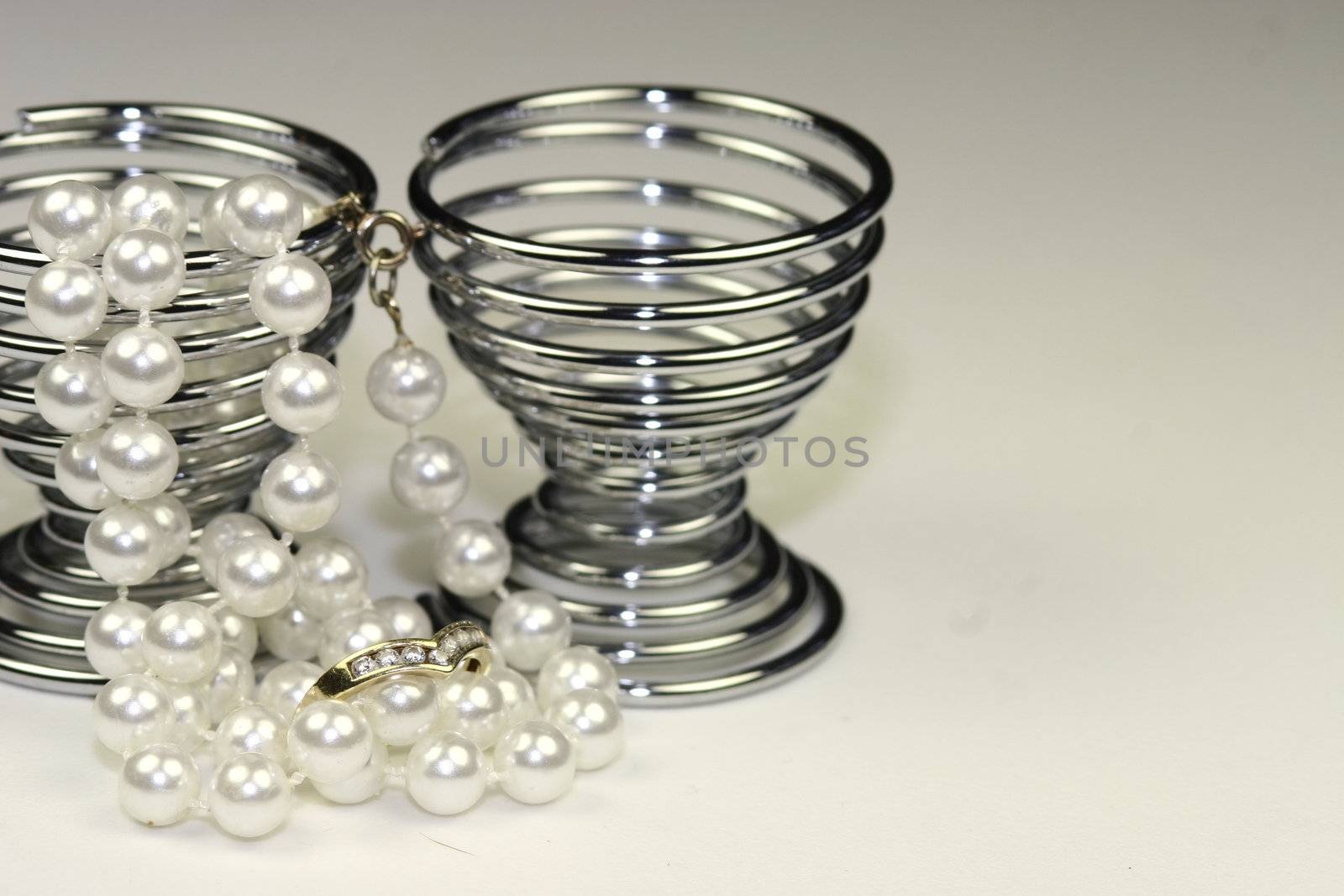 string of pearls with a wishbone diamond engagement ring and two egg cups wedding breakfast concept