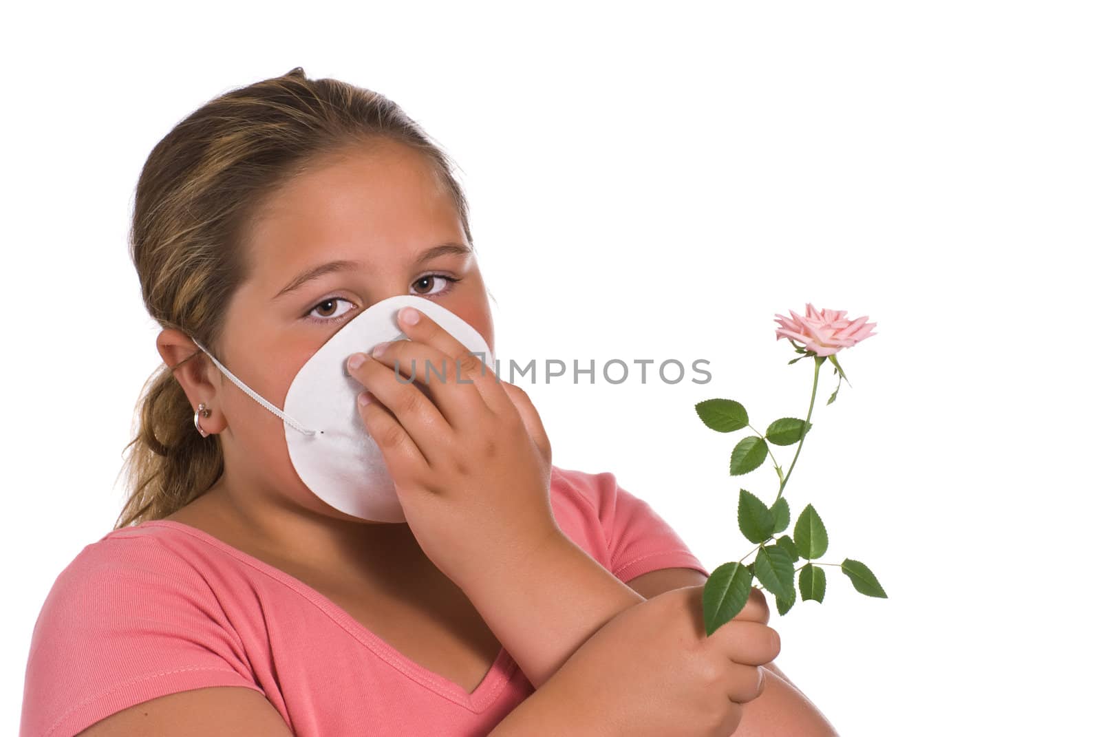 A young girl holding a flower while she wears a mask, isolated against a white background