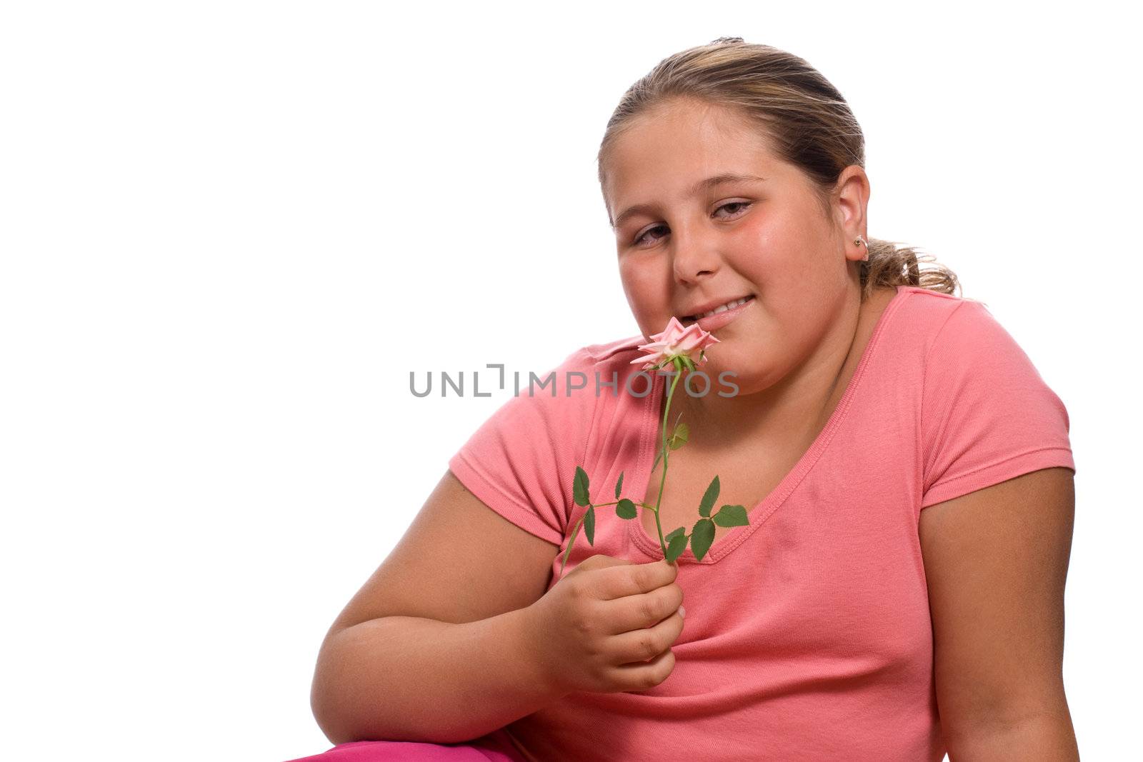 A young girl smelling a fresh rose isolated against a white background