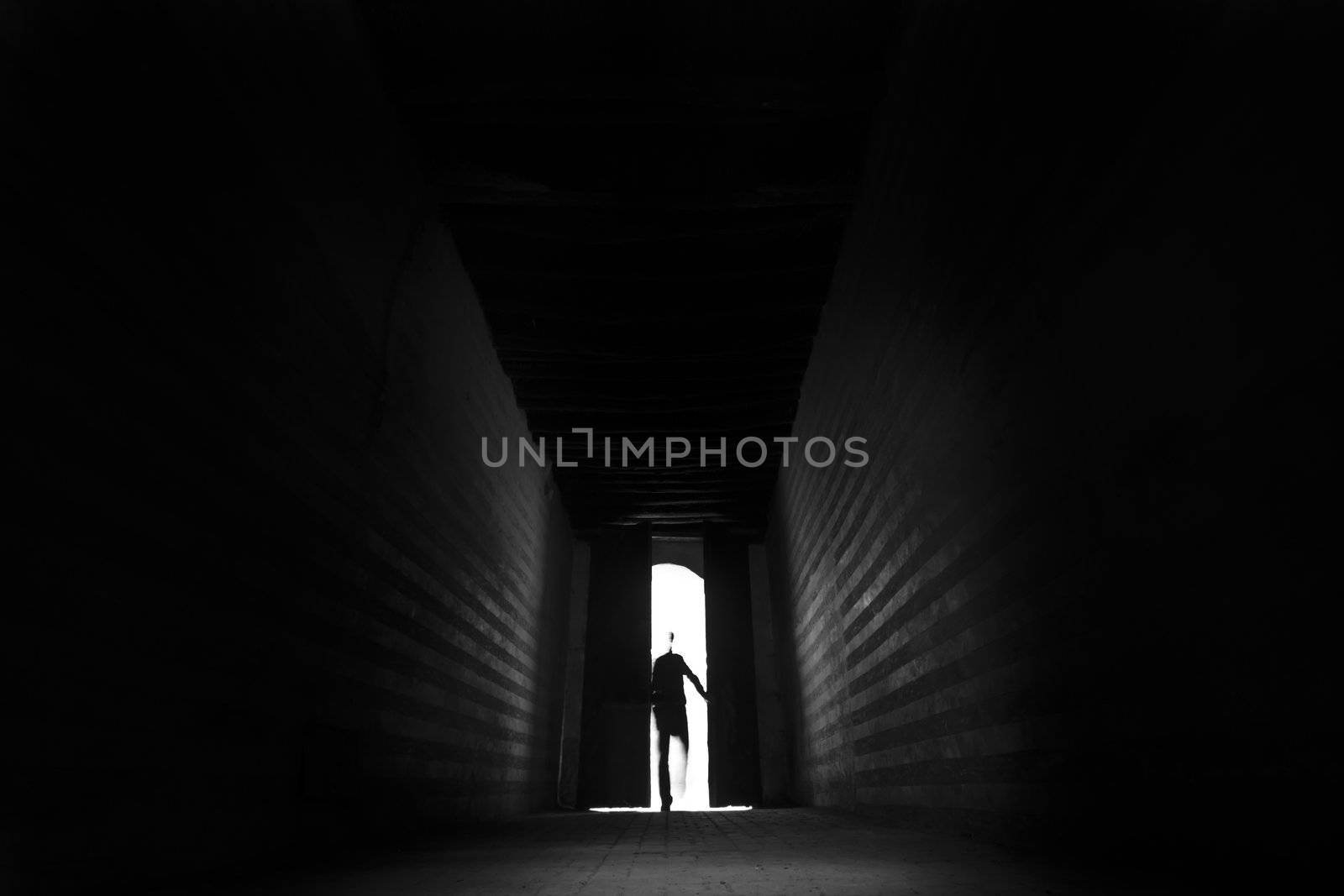 Person's silhouette entering the backlit hall