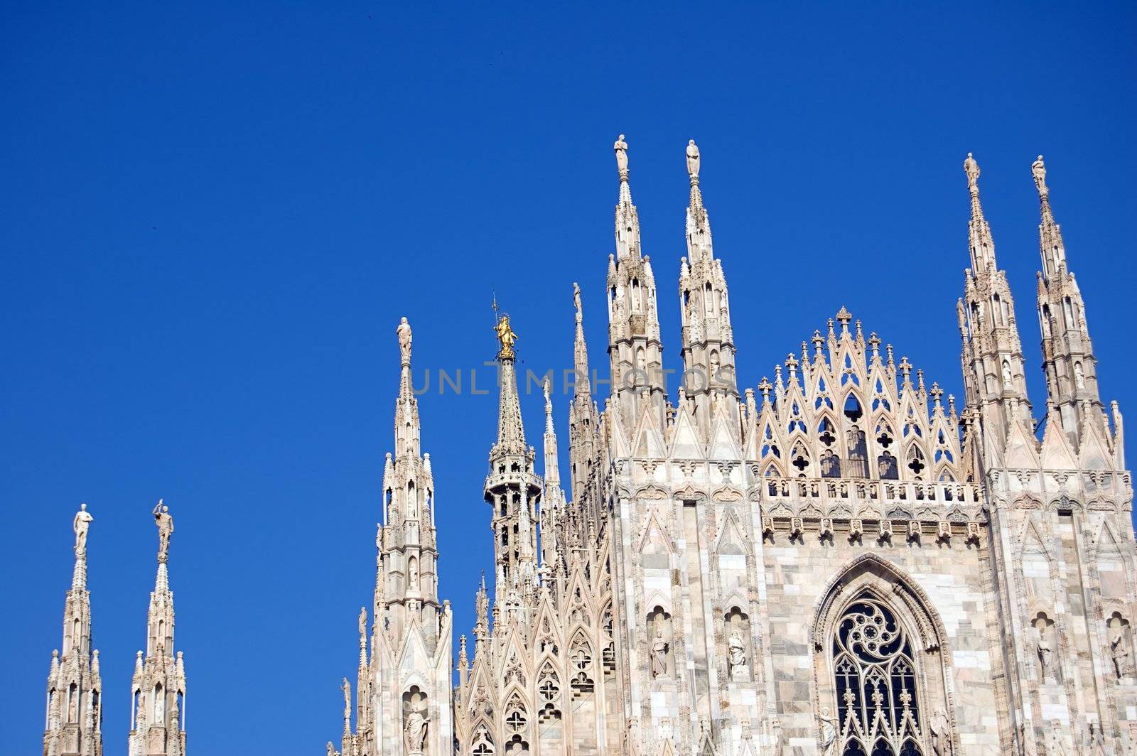 The famous Duomo, cathedral church of Milan, Italy. Details of spires with the "Madonnina" statue of the Virgin Mary