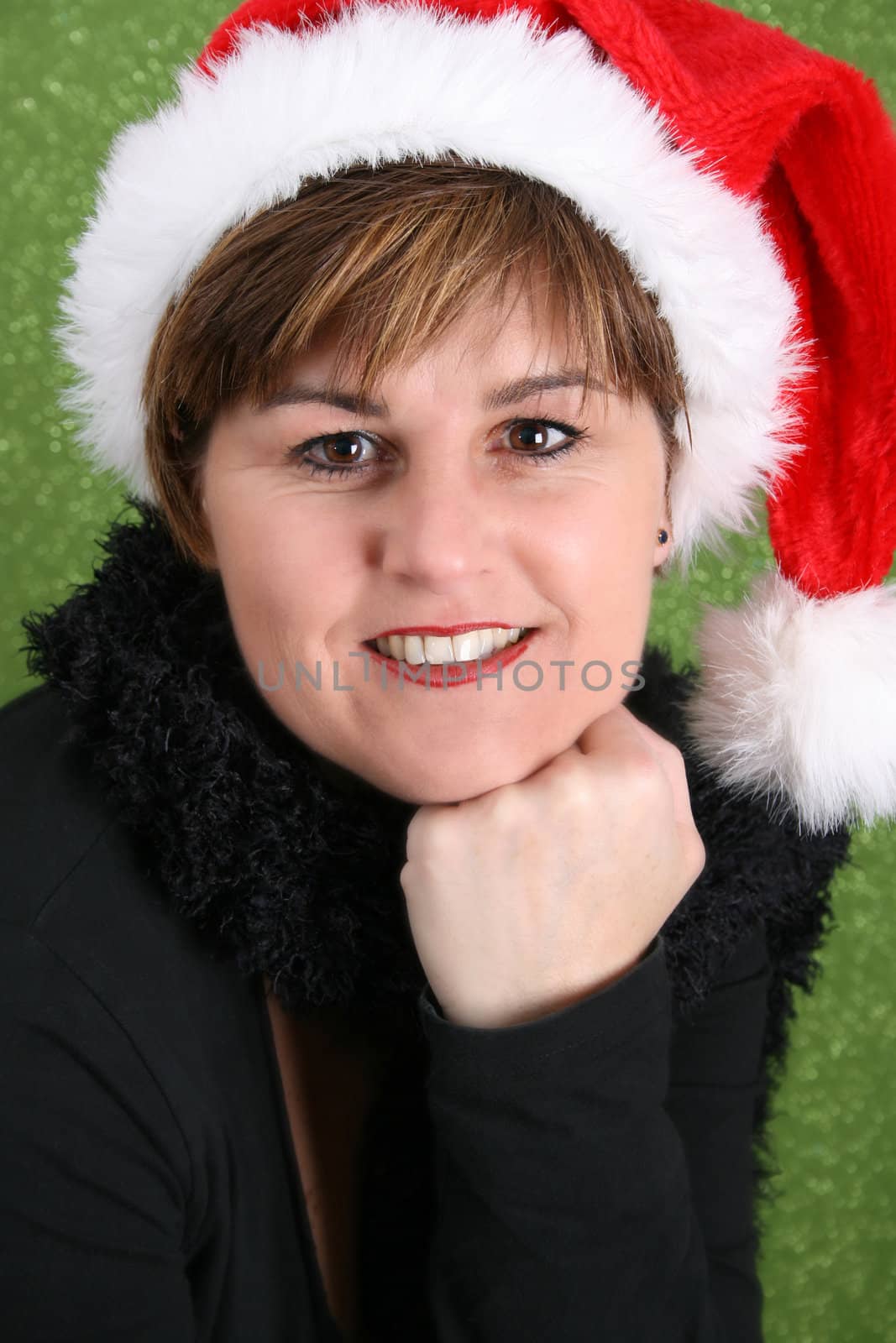 Adult female wearing a christmas hat, against a green background