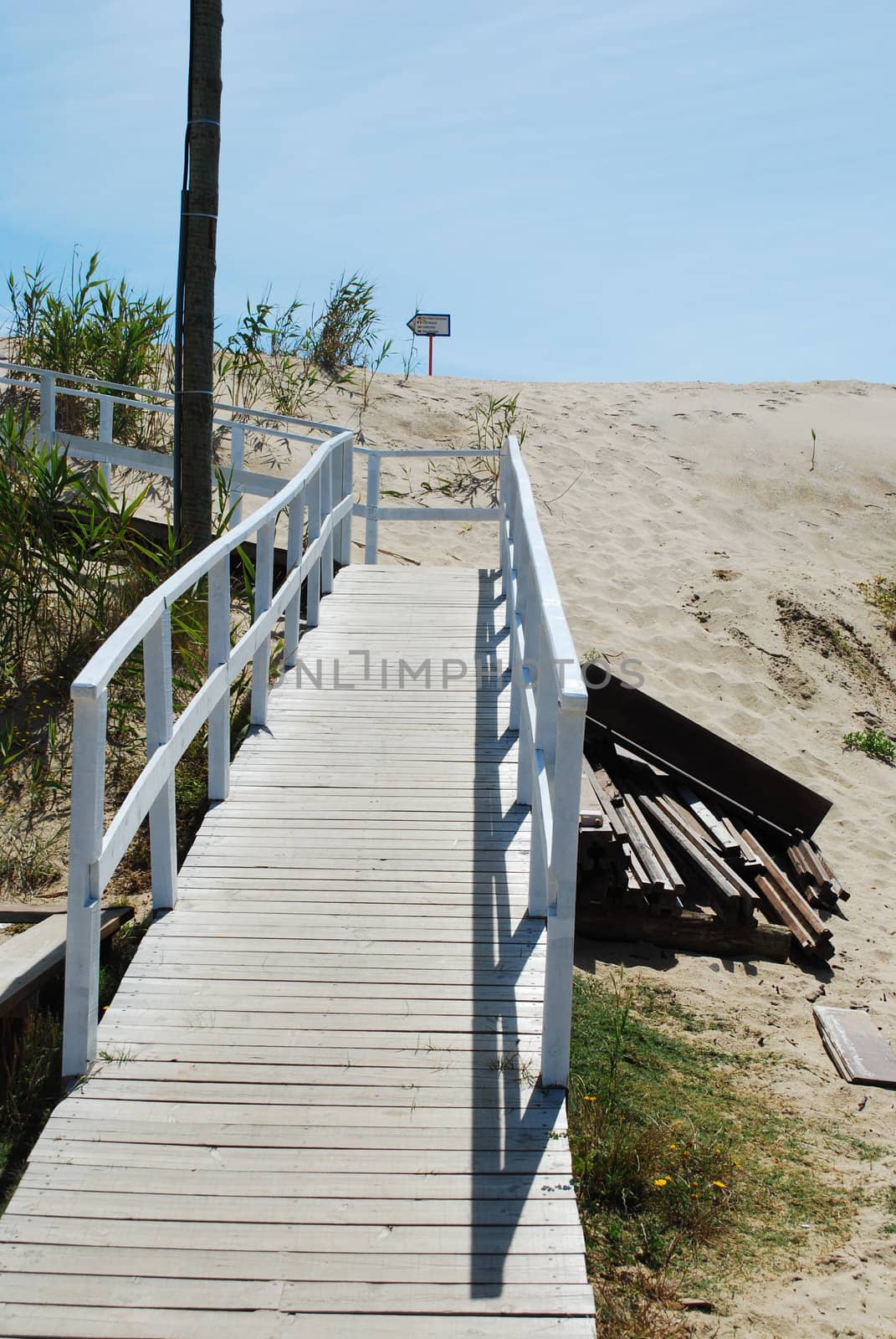 entering the beach through a white boardwalk