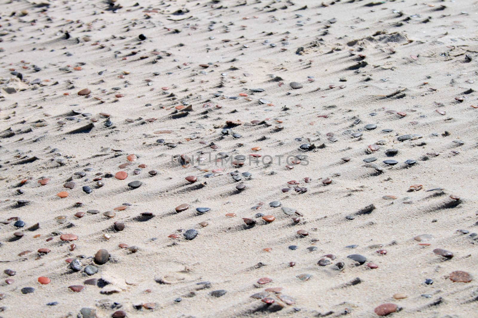 Natural sand and stone pattern on the beach, caused by the wind
