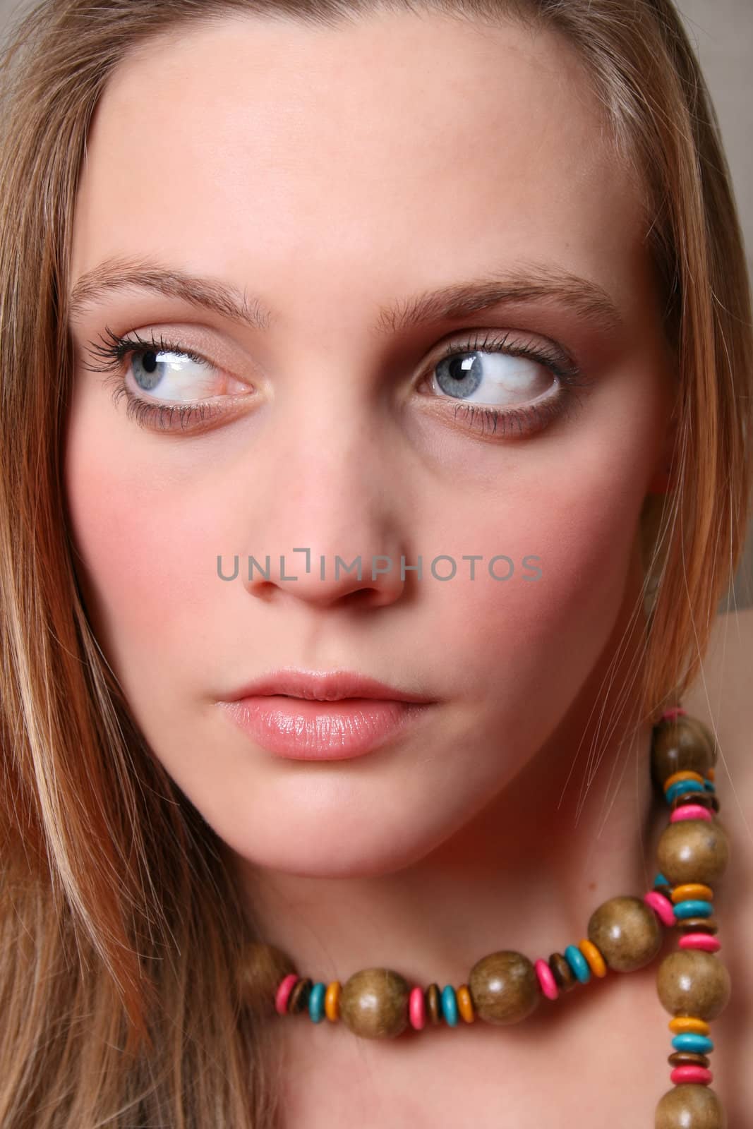 Beautiful female model with blue eyes and a string beads