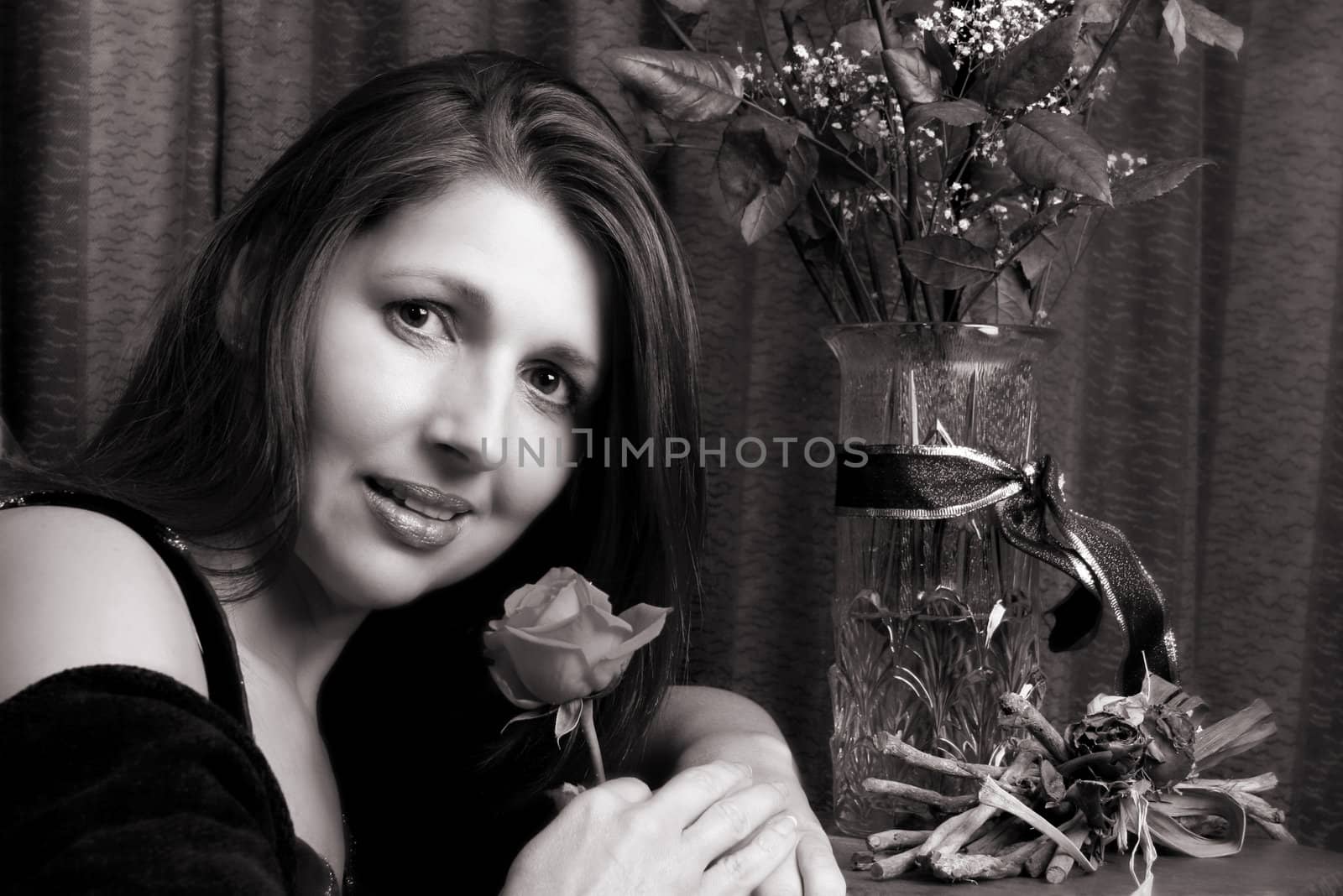 Brunette model holding a rose, looking at the camera