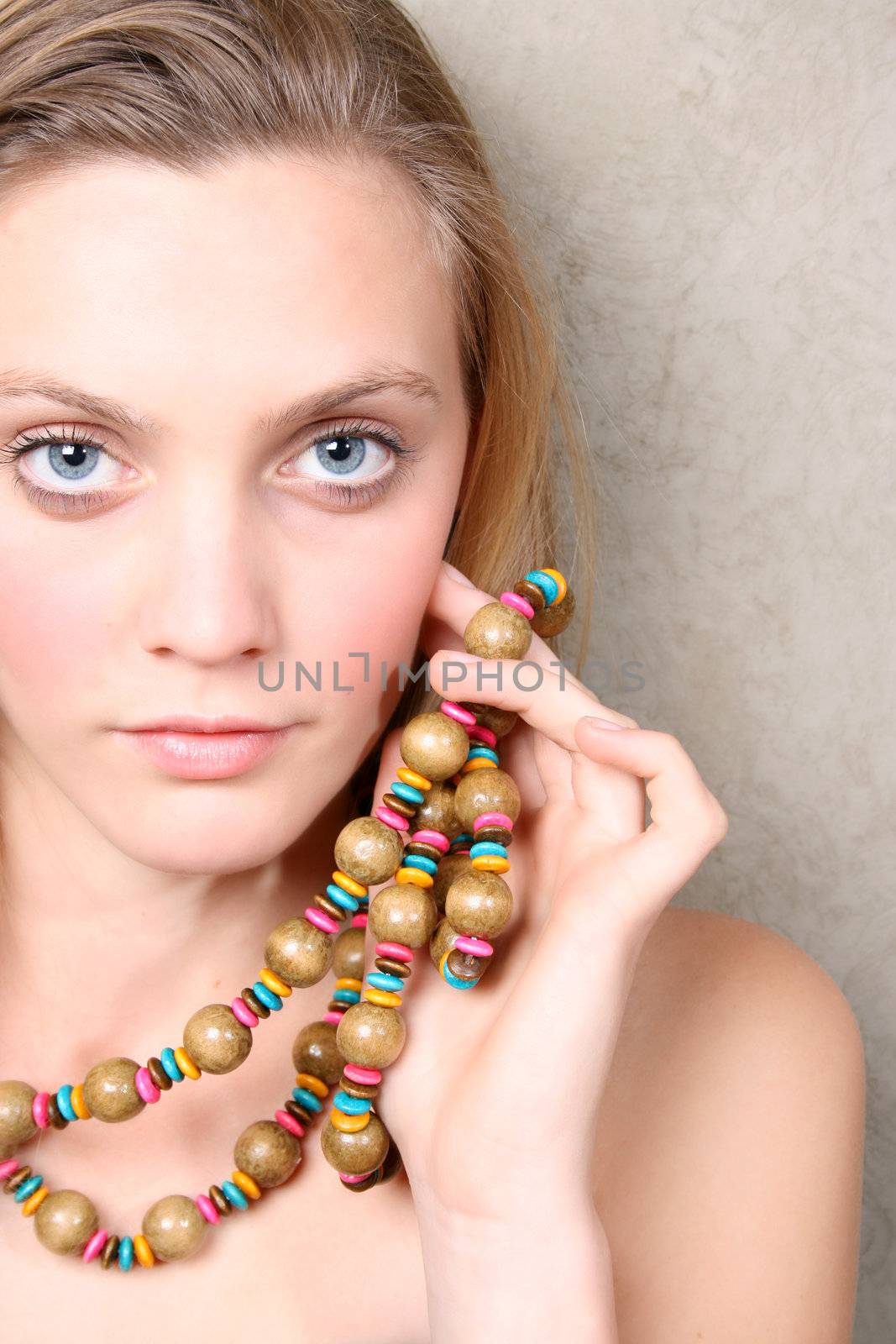 Beautiful female model with blue eyes and a string beads